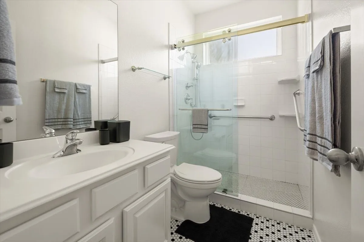 Bathroom featuring a white vanity with integrated sink, framed mirror, and chrome fixtures