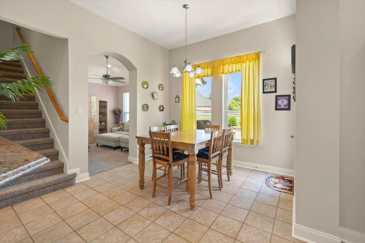 Dining area featuring tile flooring, a window providing natural light, and an arched doorway