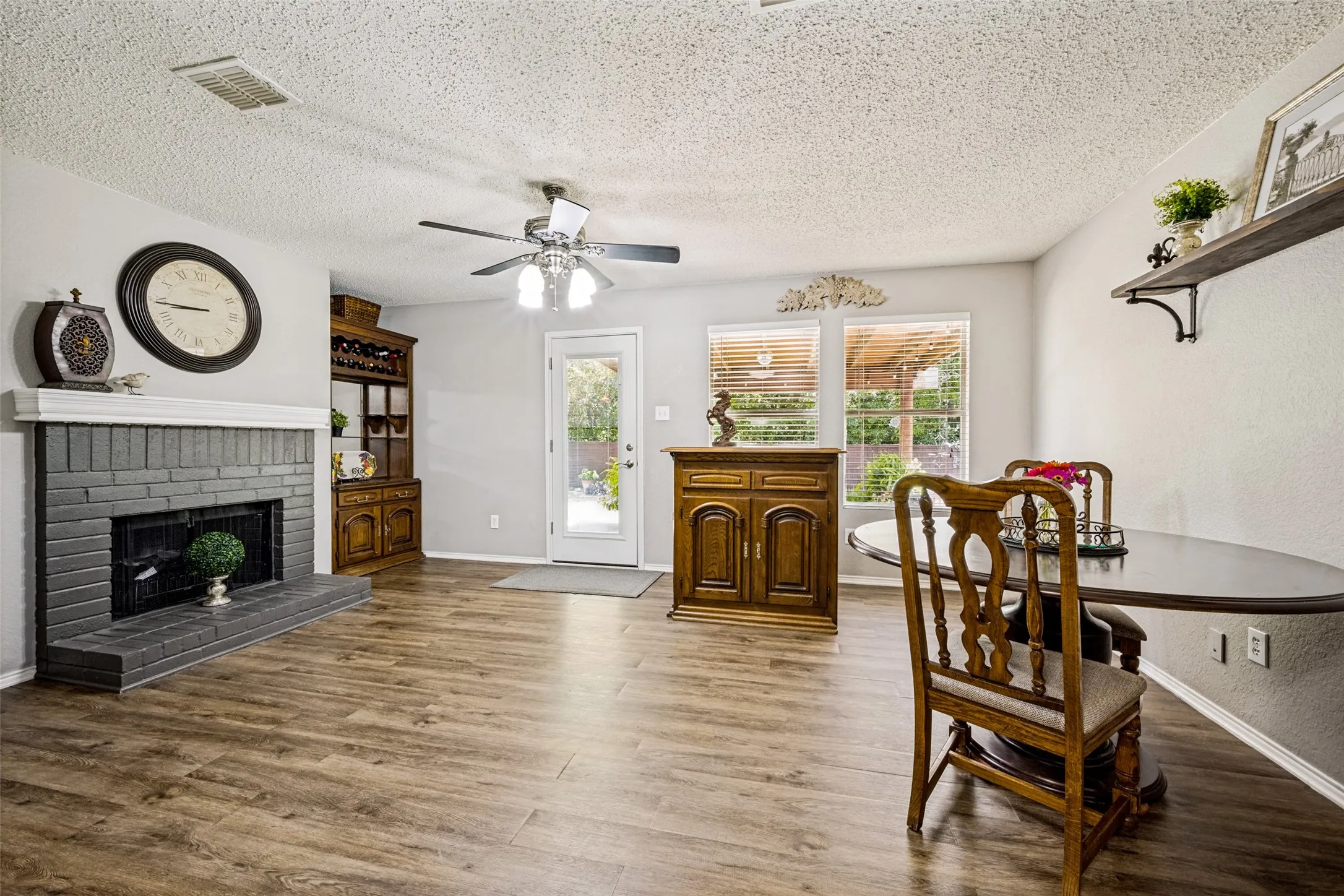 Family Room with brick, wood burning fireplace and Breakfast area opens to the Kitchen with views of the lovely large, private backyard and patio.