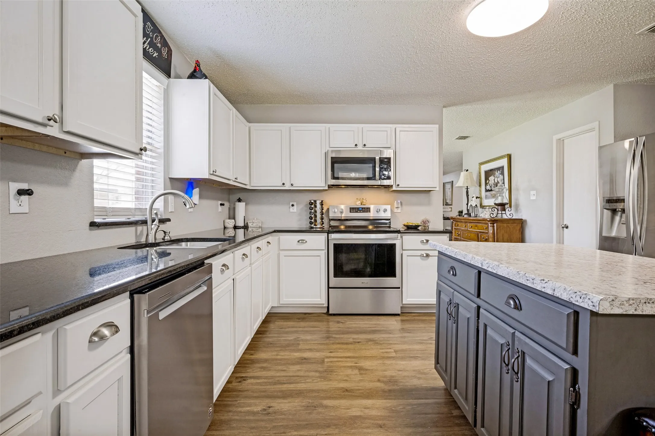 Kitchen is made for entertaining, features an abundance of cabinets, walk-in pantry, coffee bar, stainless appliances, microwave and dishwasher. The kitchen is open to the Family Room and has views of patio and backyard.