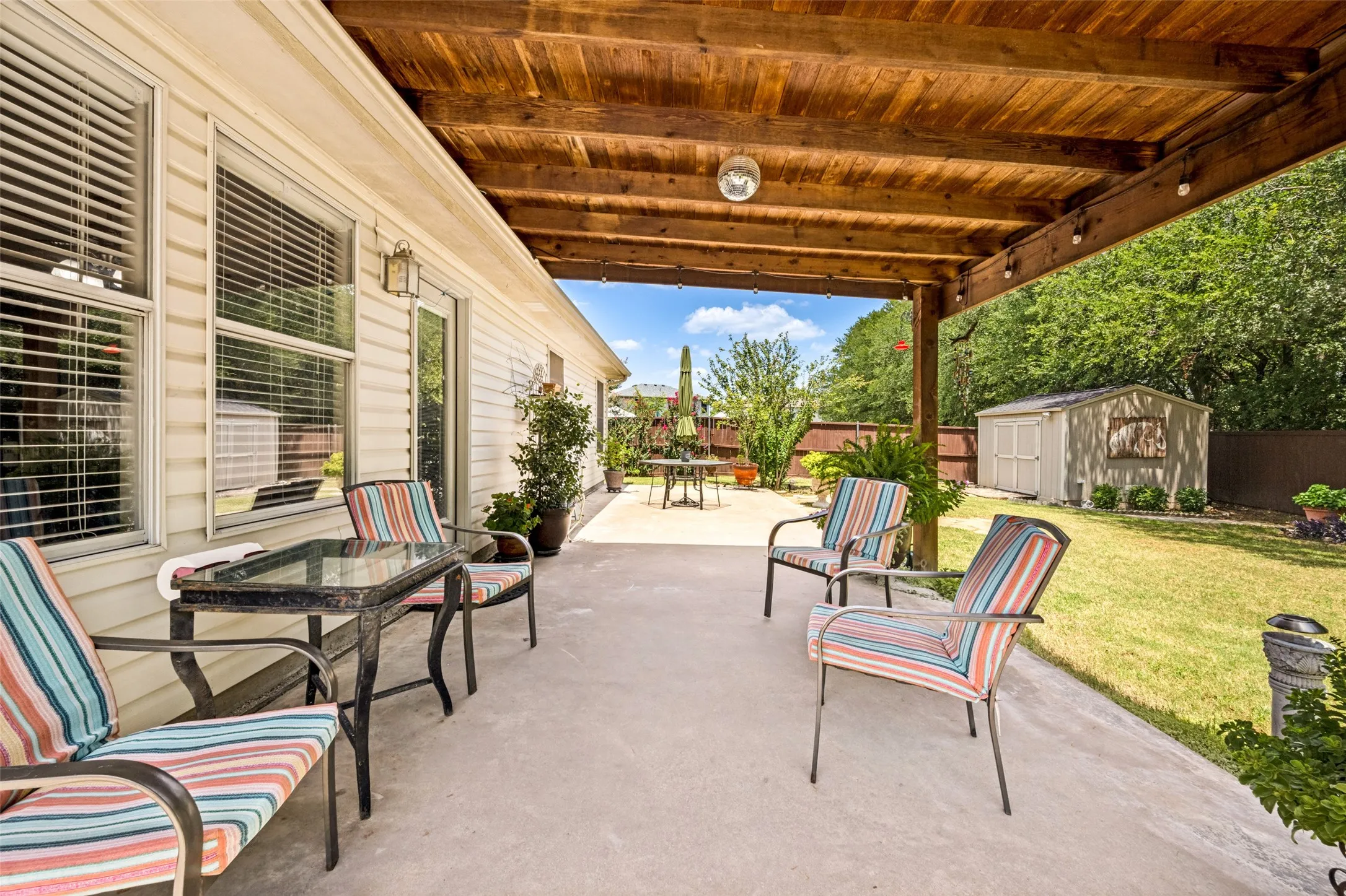 Covered Patio features a pergola cover, an additional patio accommodates those large cookouts. The yard is private, the tree line encourages relaxing outdoors. The Garden Shed in the background is 10' X 12'.