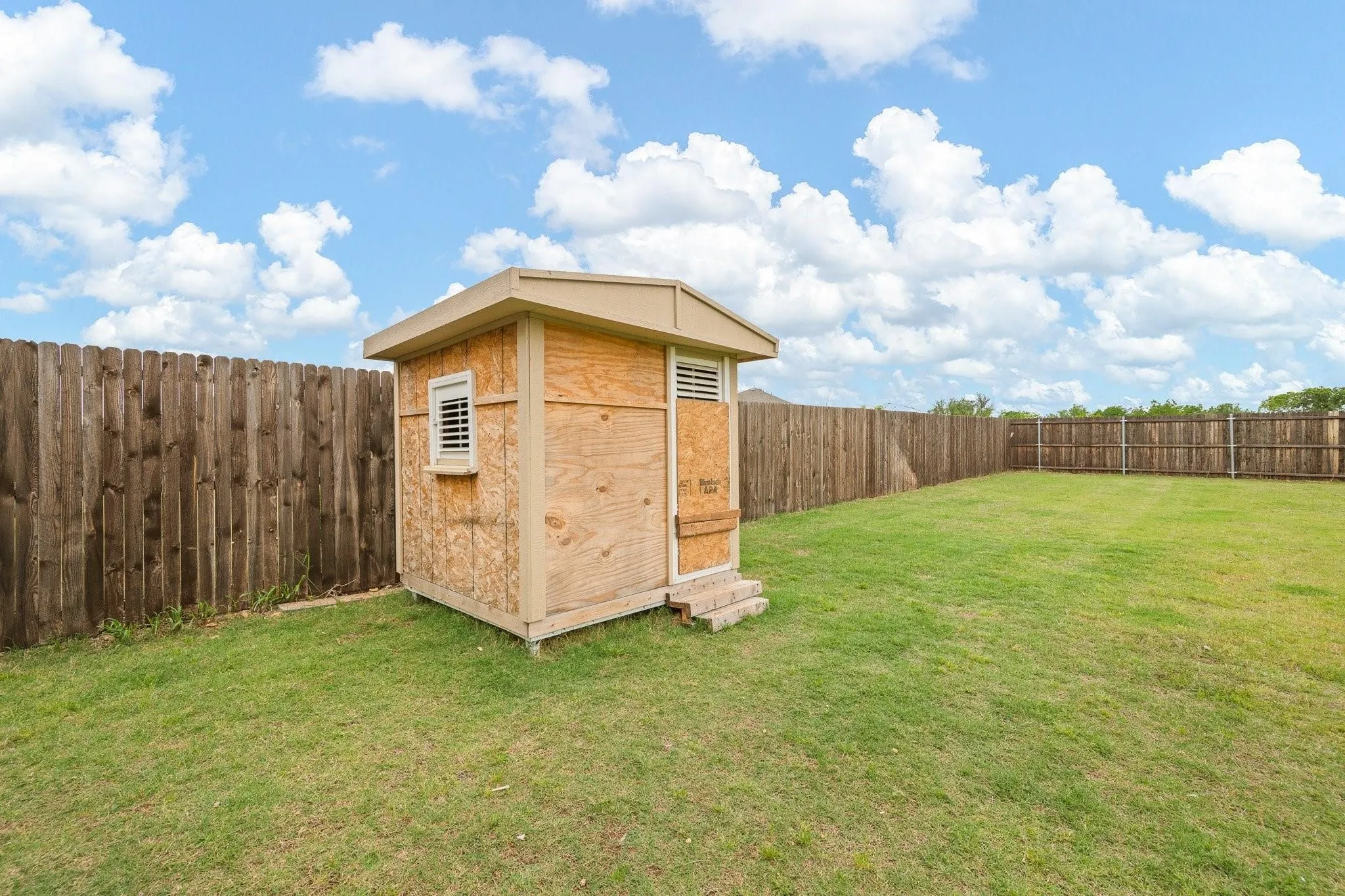 Charming wood storage shed situated in the backyard, offering convenient additional storage space for tools and equipment.
