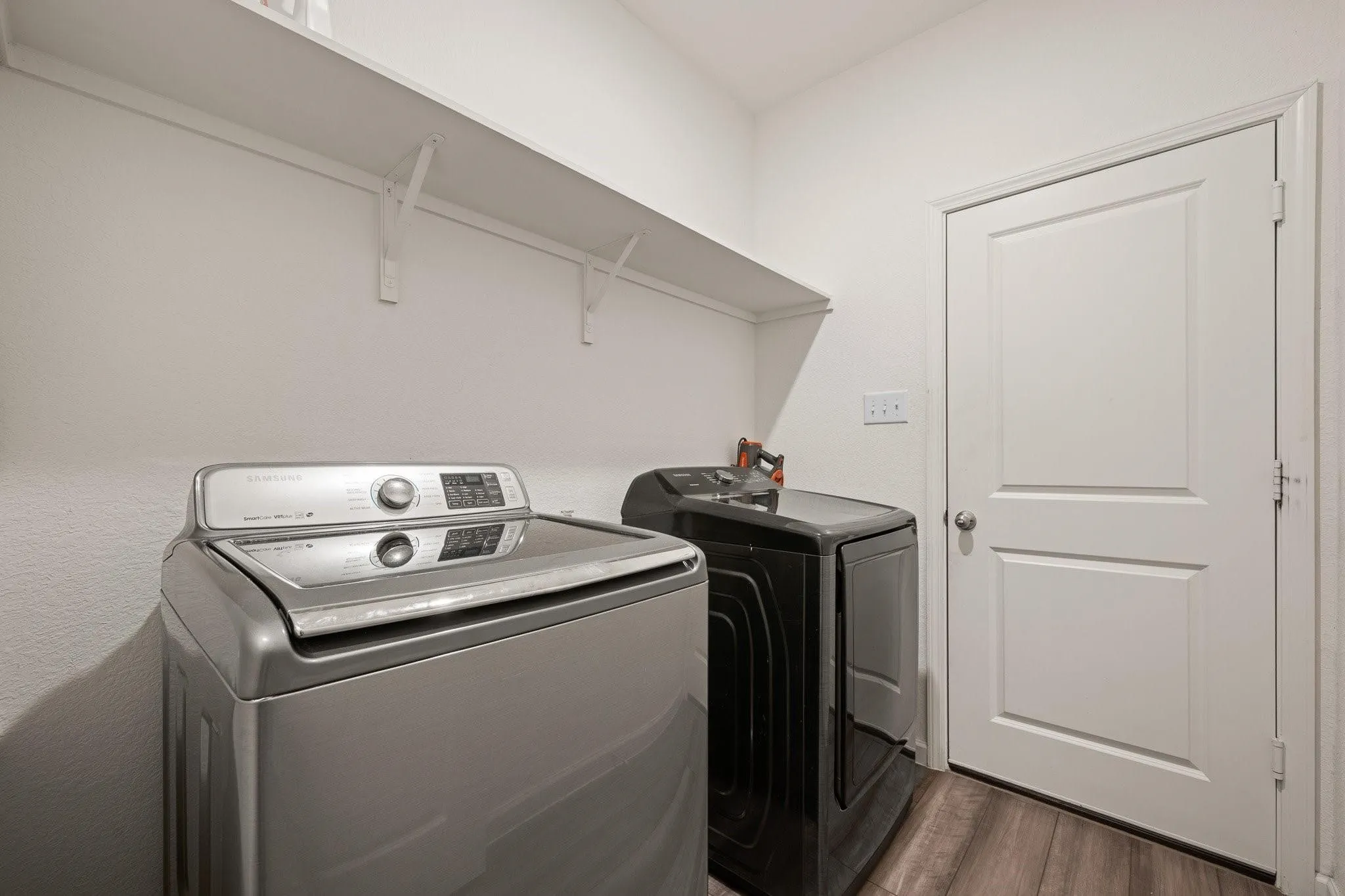 Dedicated laundry room with washer and dryer hookups and additional storage space, conveniently located inside the home.