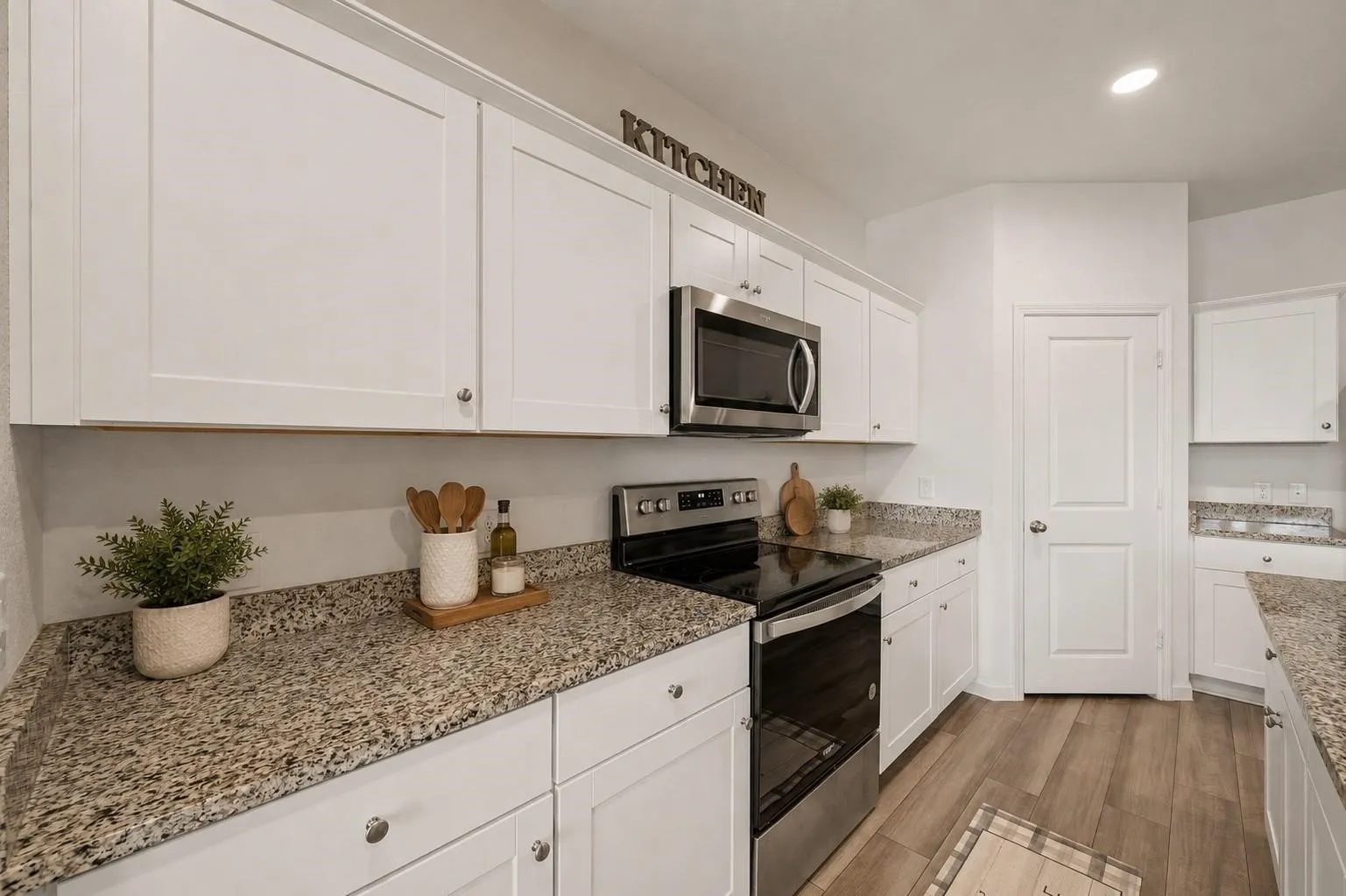 Additional kitchen angle showcasing the expansive counter space, island seating, and connection to the dining and living areas. Decor is Virtually Staged