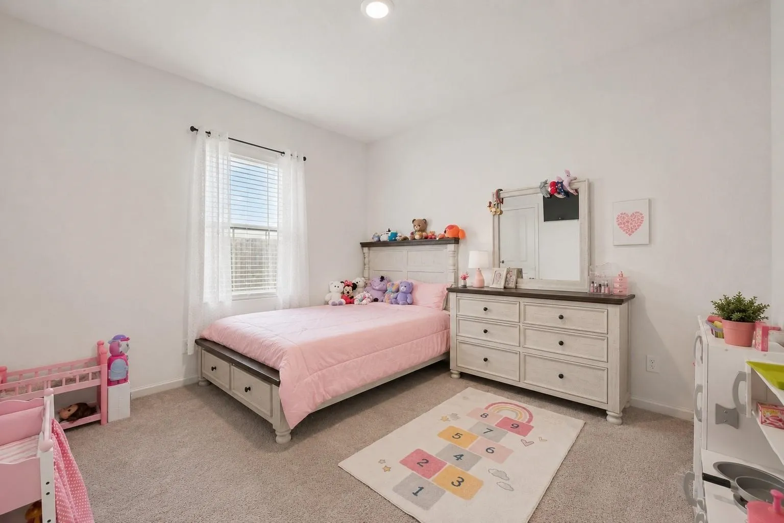 Secondary bedroom with cozy neutral tones, large window, and versatile layout suitable for bedroom or home office use.