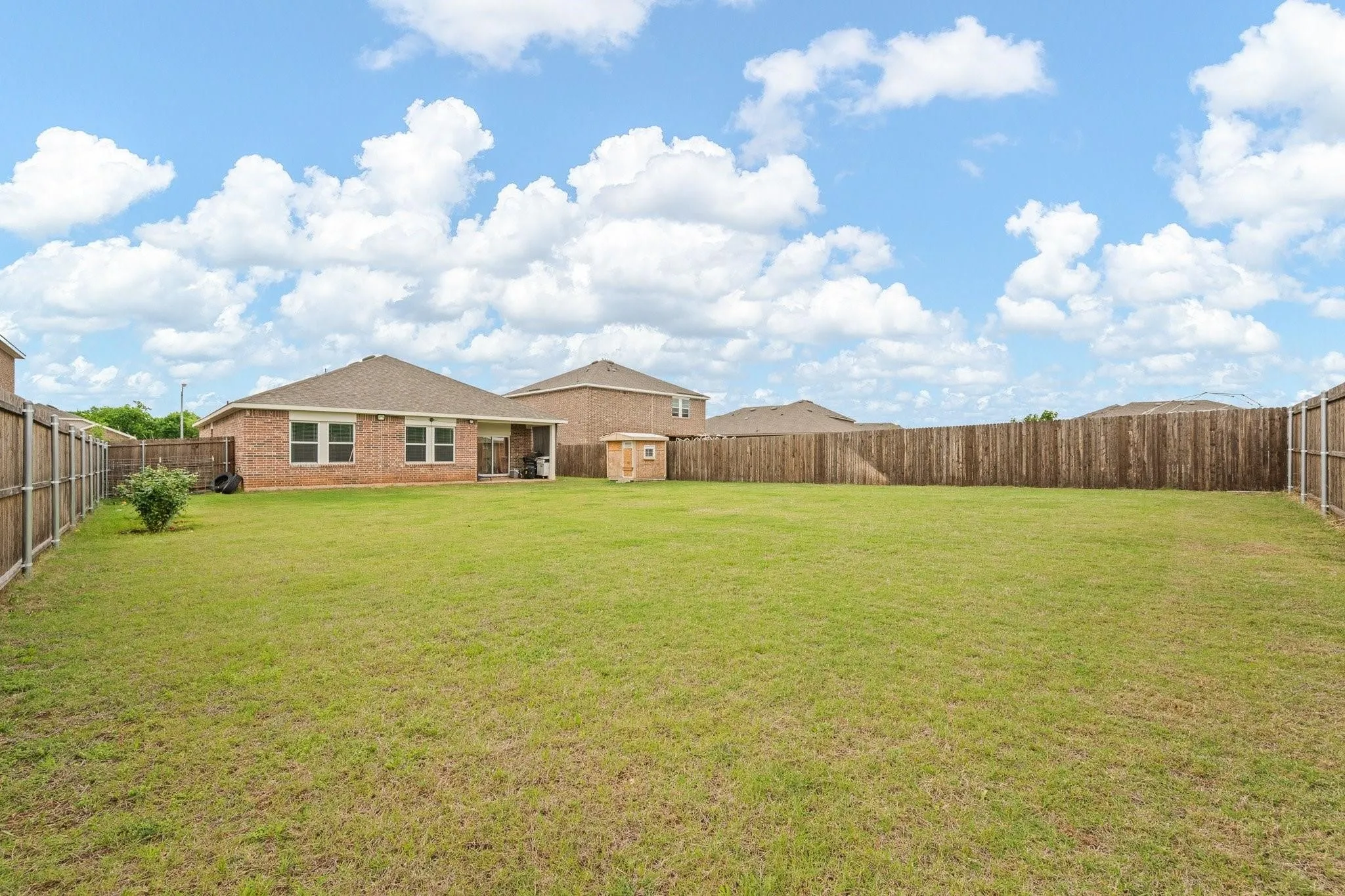 Expansive backyard with lush green grass, open sky, and plenty of room for outdoor entertaining and activities.
