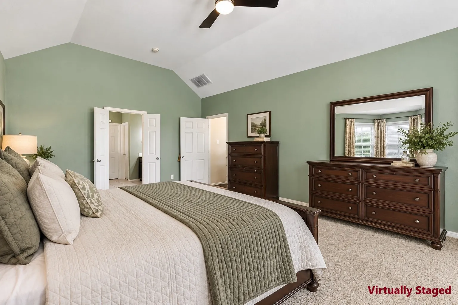 Vaulted ceiling with a ceiling fan, carpeted flooring, and light green painted walls