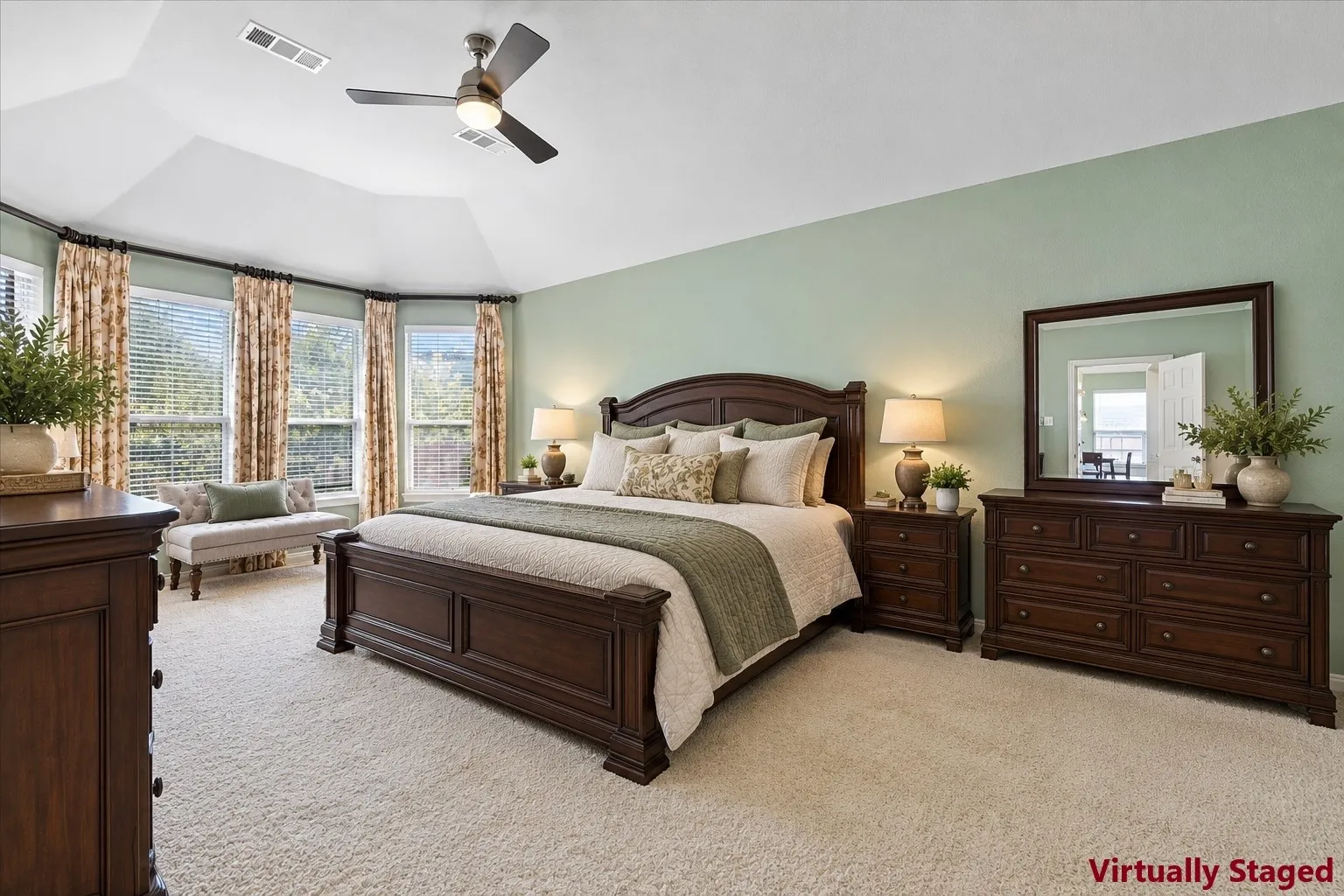 Vaulted ceiling with a ceiling fan, bay window with blinds, and light-toned carpet flooring