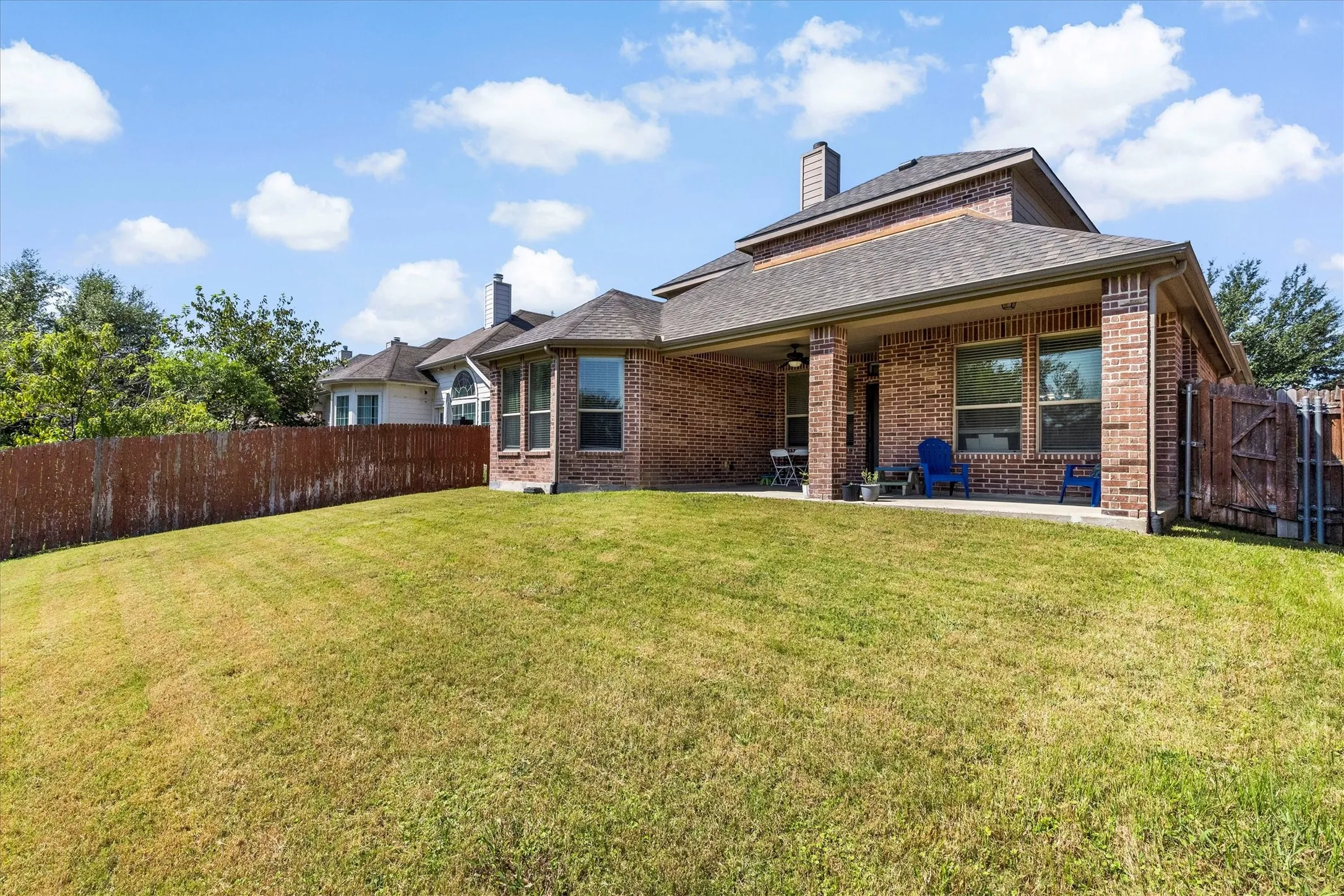Expansive backyard with a sloped lawn and full privacy fencing