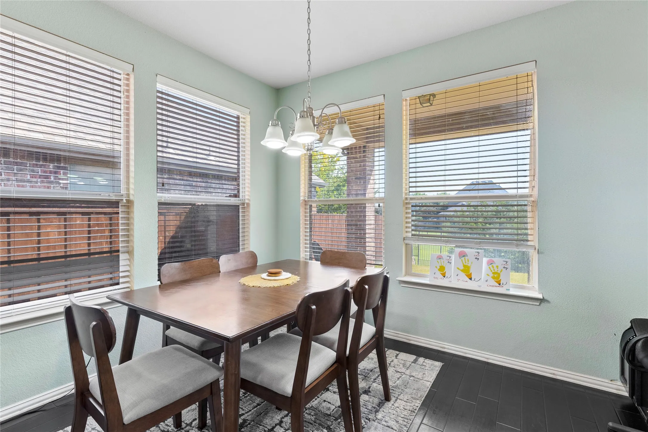 Dining area featuring dark wood-finish flooring and a multi-light chandelier