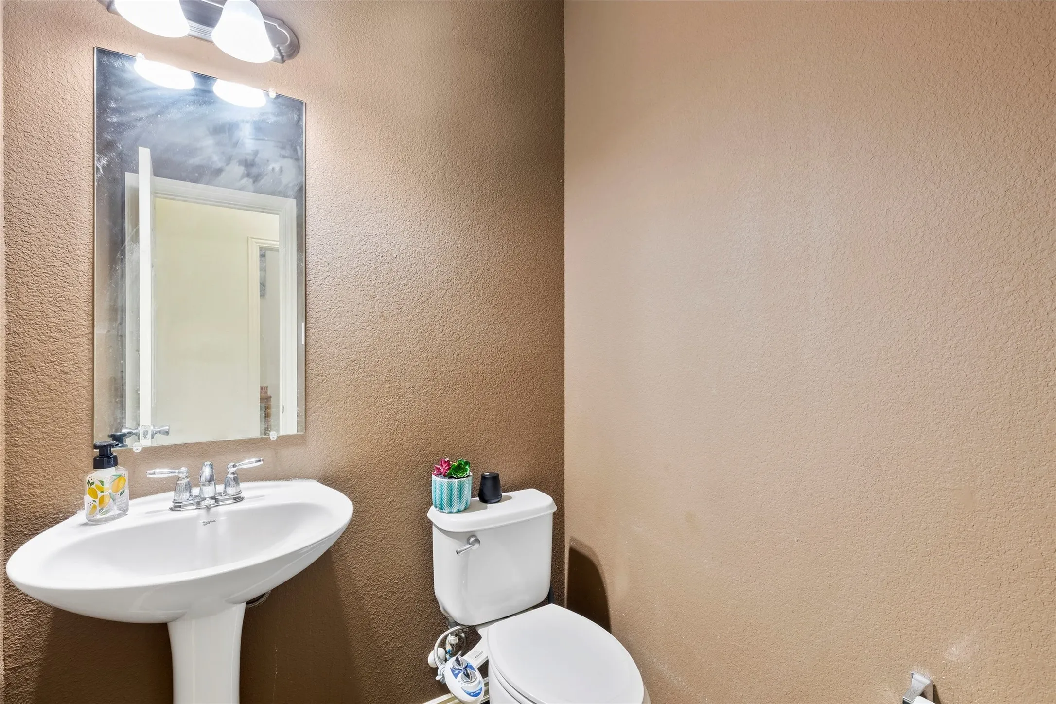 Pedestal sink with chrome faucet and rectangular mirror