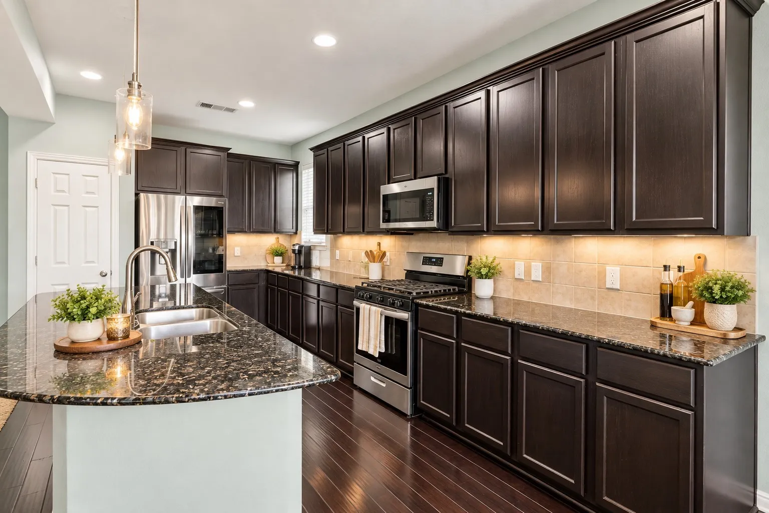 Gourmet kitchen featuring dark wood cabinetry, granite countertops, stainless steel appliances, and wood-finish flooring