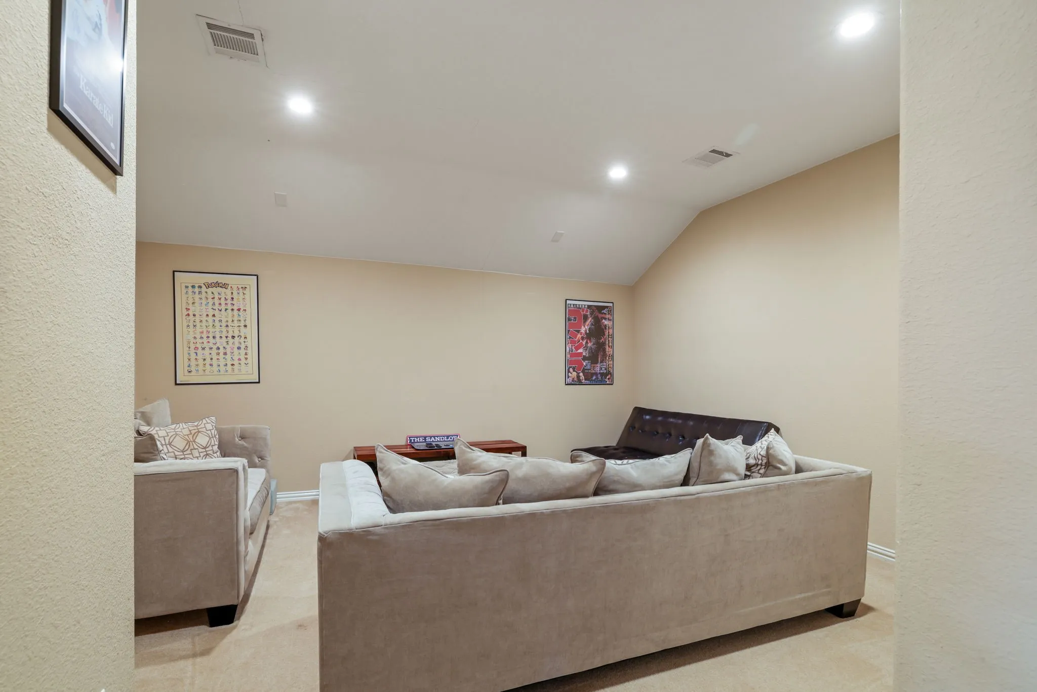 Carpeted room with recessed lighting and a vaulted ceiling