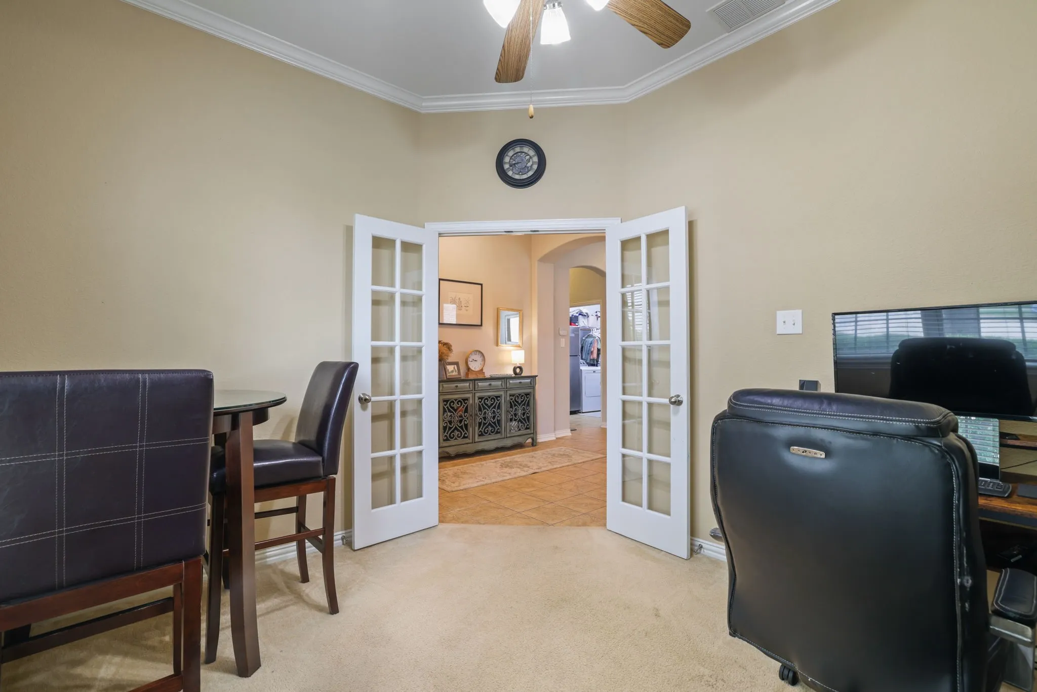 French doors with transom window detail, crown molding, a ceiling fan, and carpeted flooring