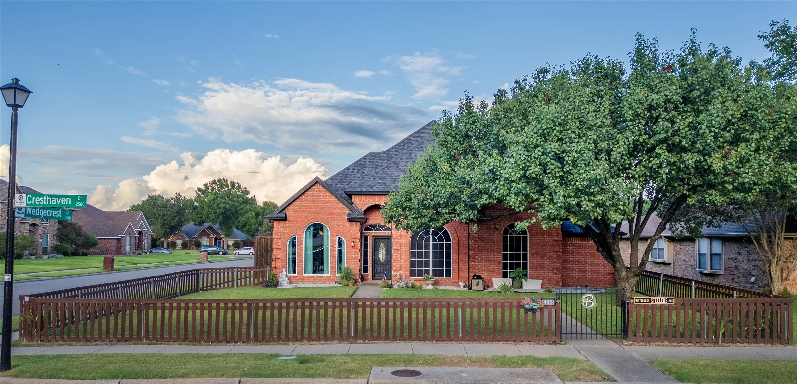 Brick facade residence featuring arched windows and a dark entry door