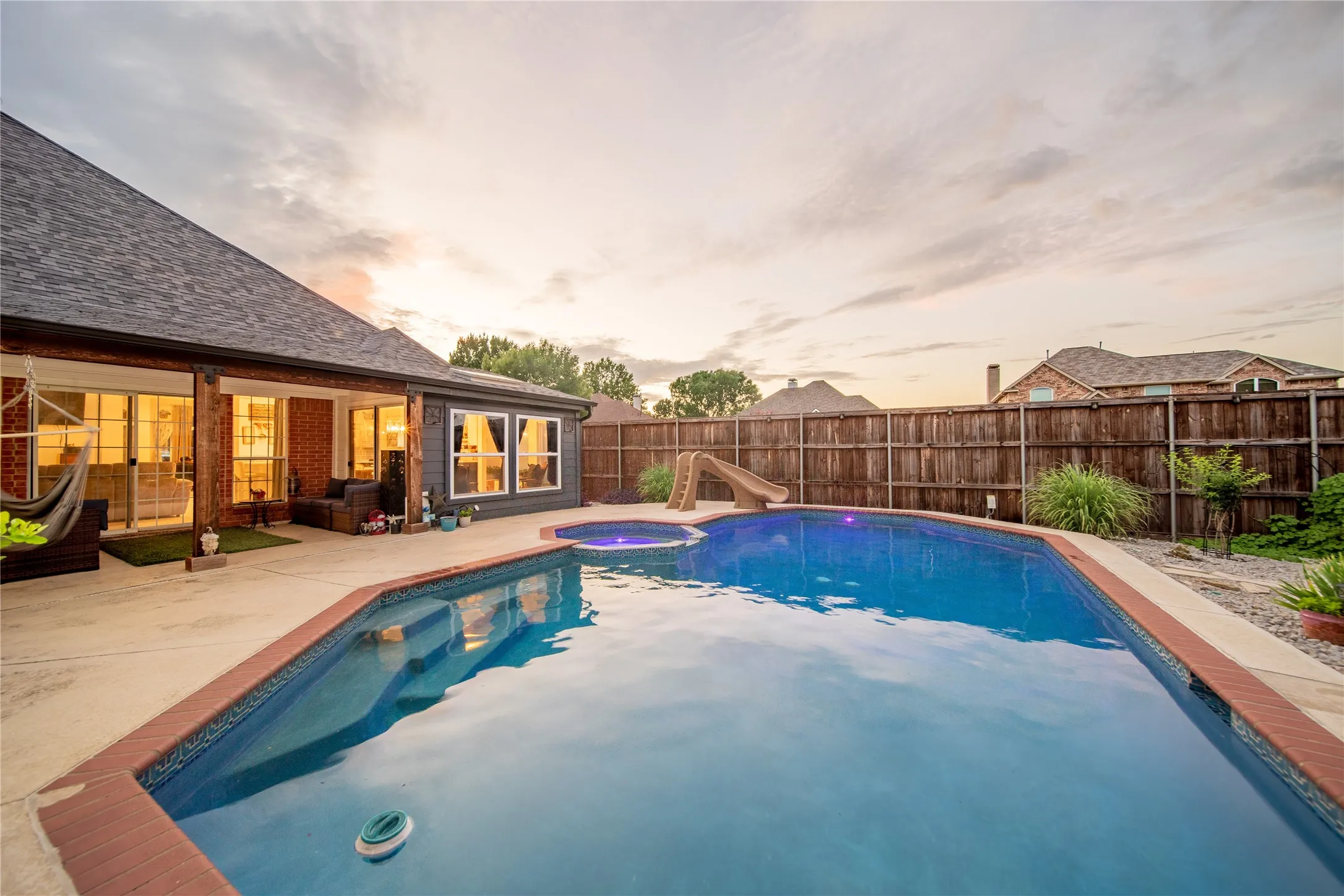 Outdoor swimming pool with integrated spa and concrete surround