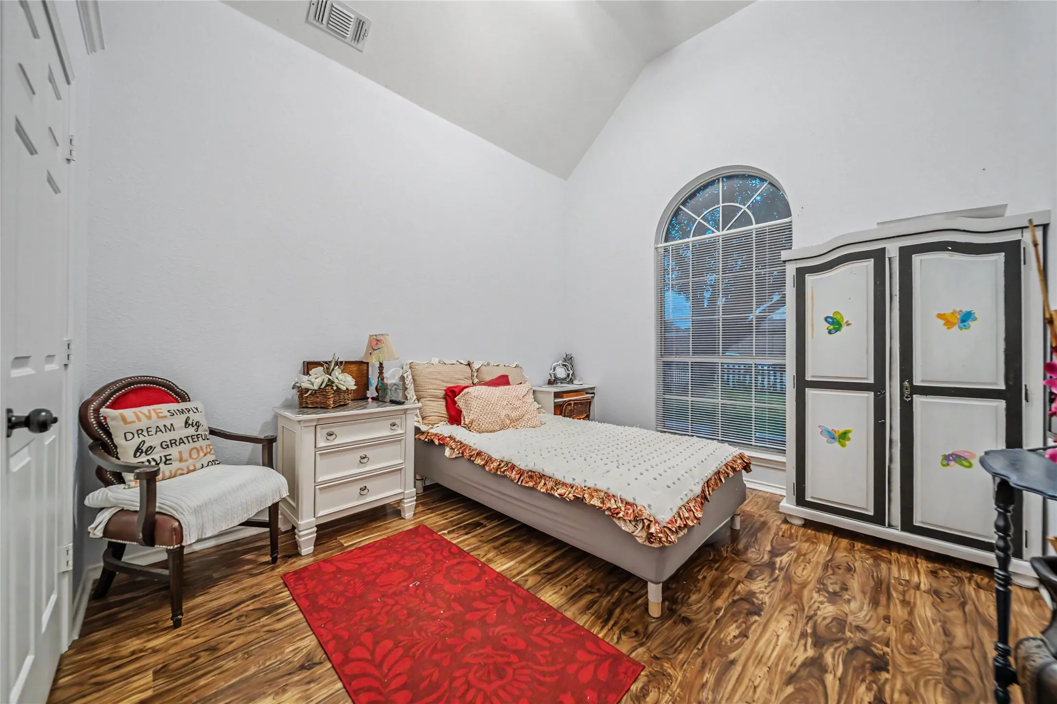 Room featuring a vaulted ceiling and wood-finish flooring