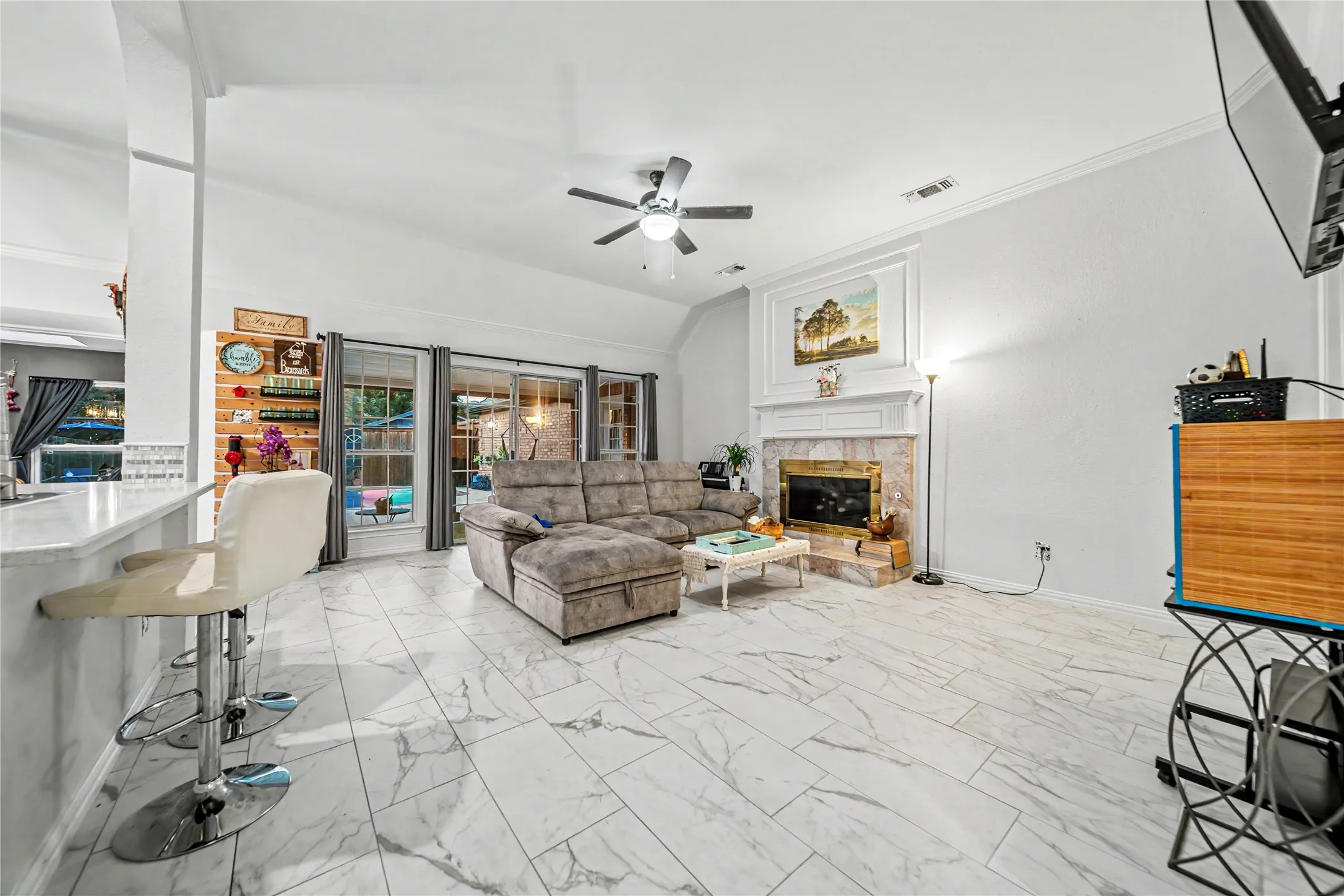 Open-concept living area with large-format marble-look tile flooring