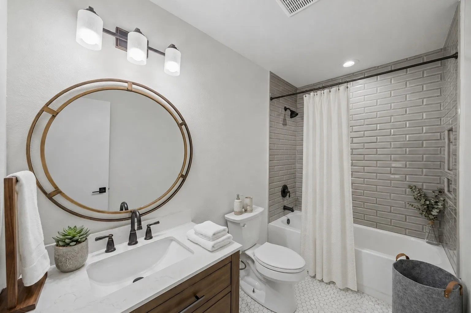 The renovated guest bath features a furniture-style vanity, quartz countertop, designer hex tile flooring and a tiled shower surround.
Virtually Staged -- original image may have been altered by AI.