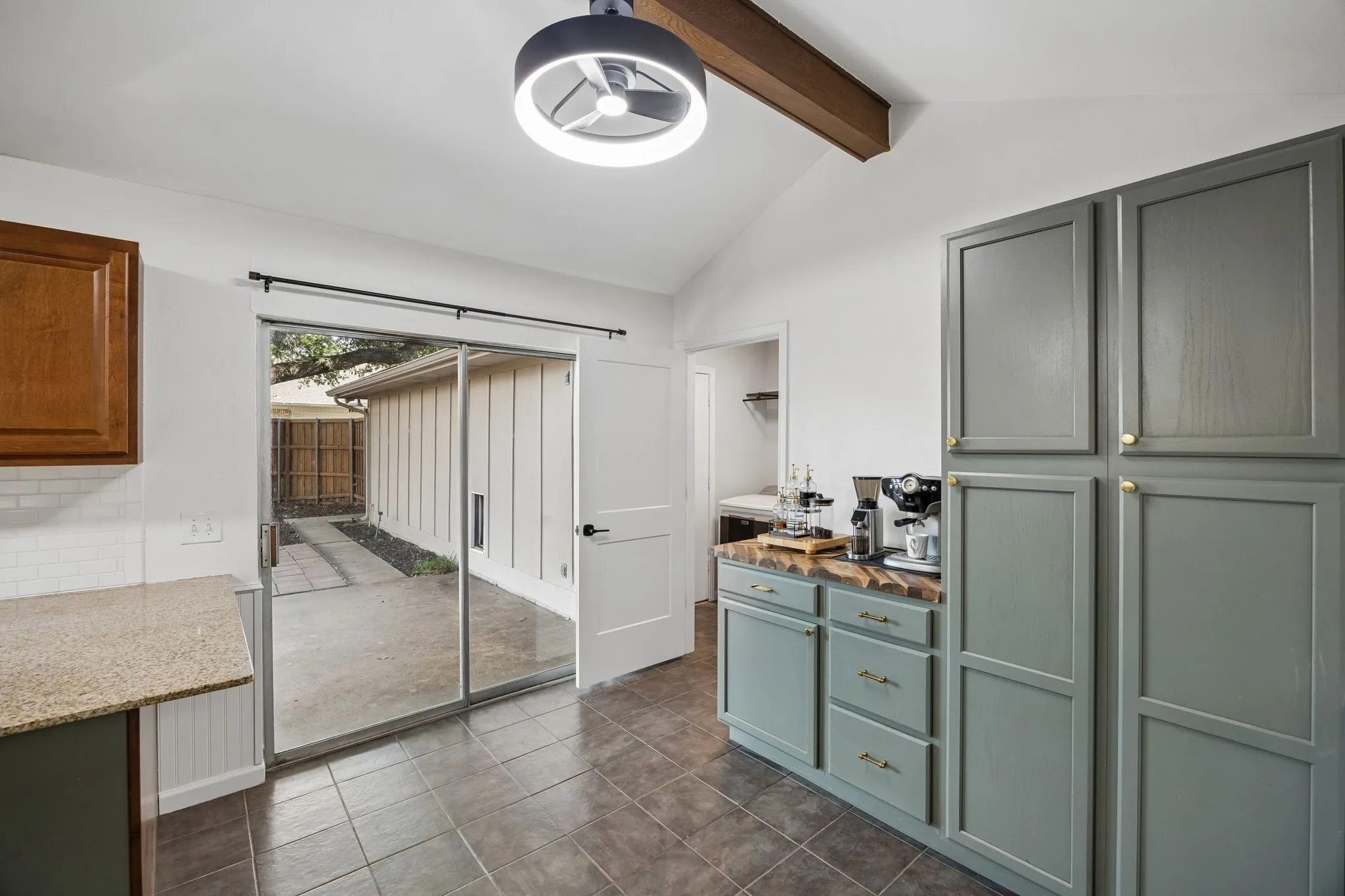 A wide view showcases the kitchen’s workspace, peninsula seating and the custom cabinetry extending storage beyond the traditional kitchen.