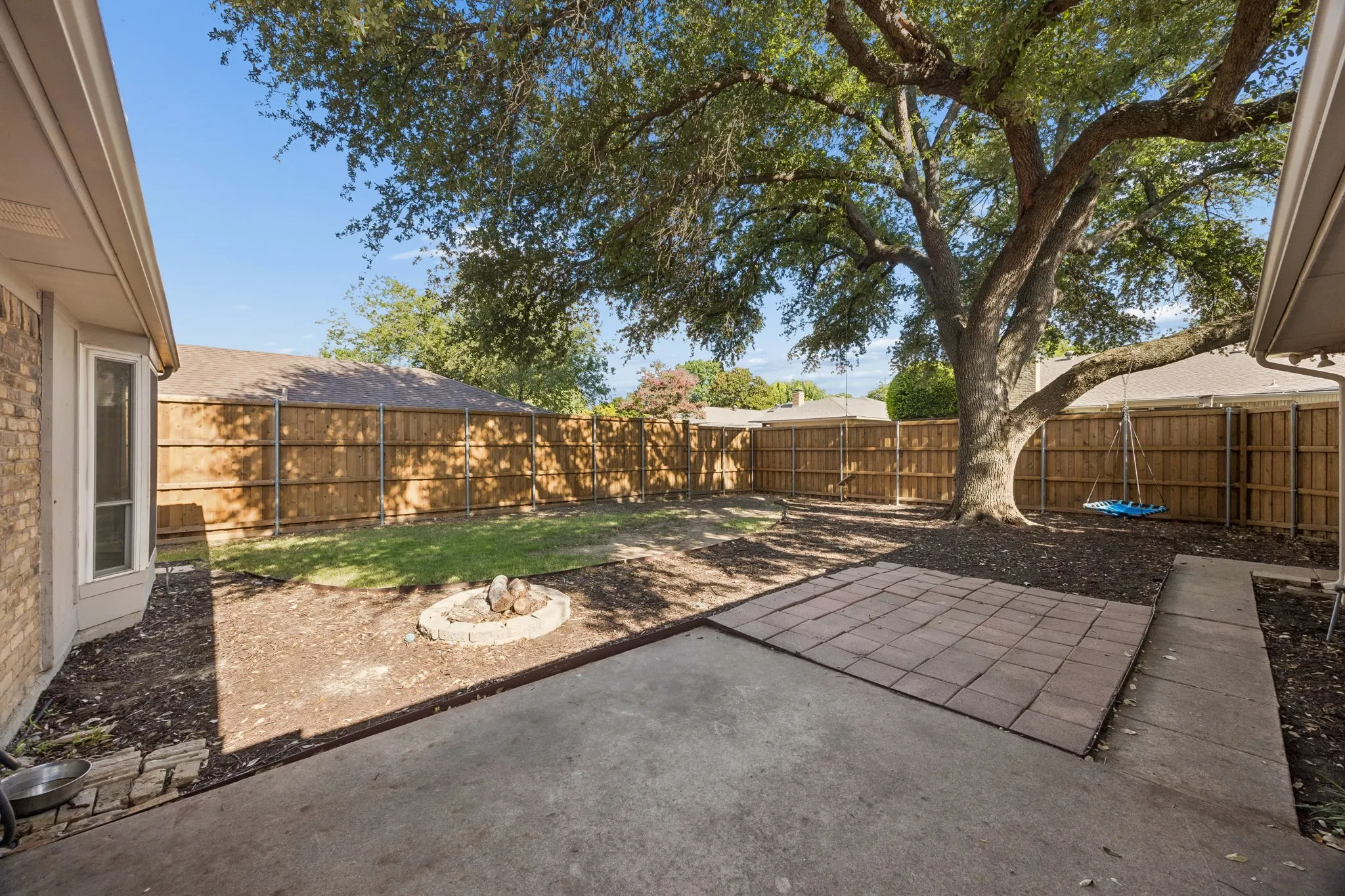 A designated firepit area, extended flatwork and board-on-board privacy fencing provide a versatile setting for outdoor enjoyment.