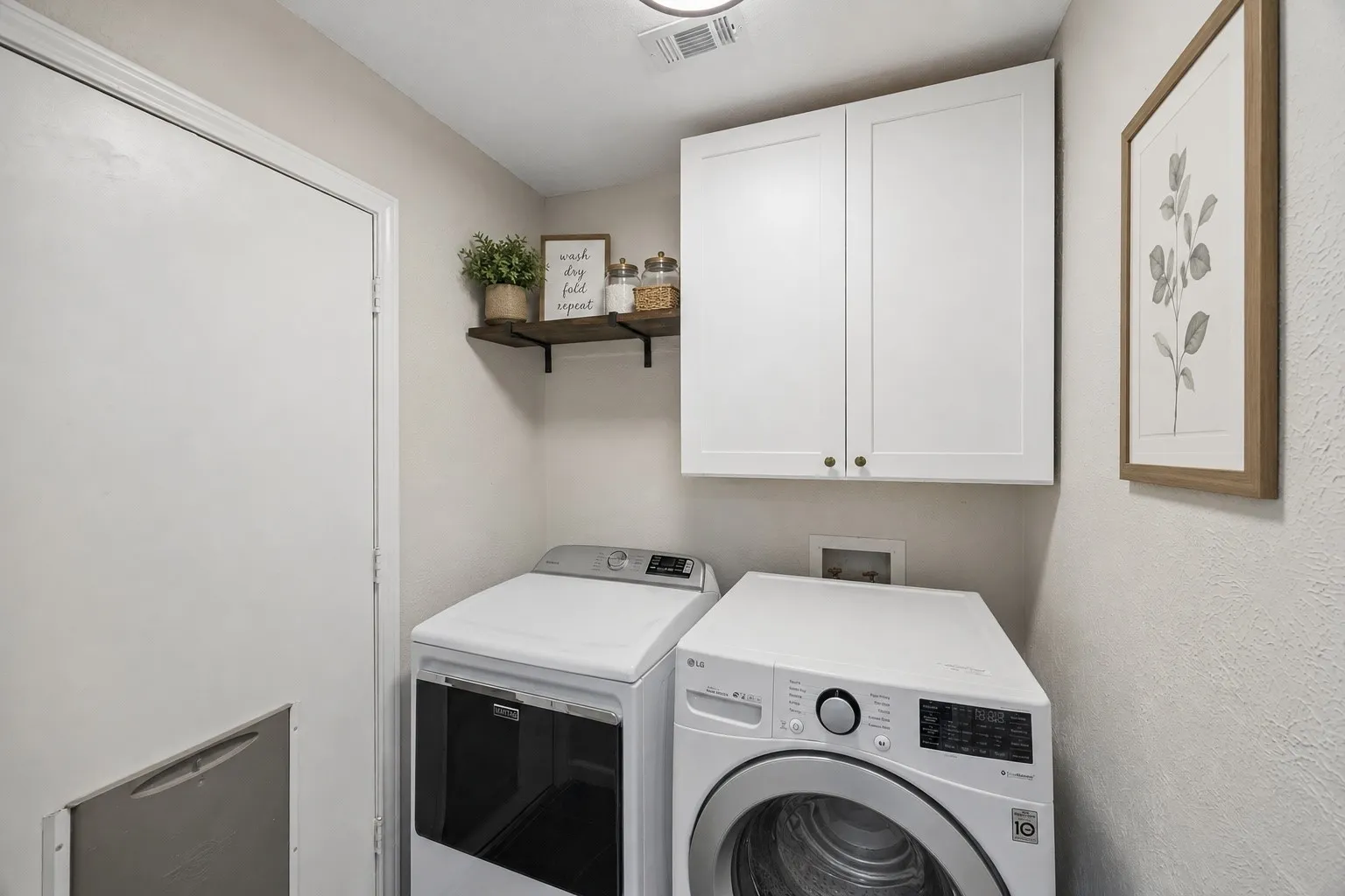 The dedicated laundry room includes upper cabinetry and shelving to keep everyday supplies organized and within reach.
Virtually Staged -- original image may have been altered by AI.