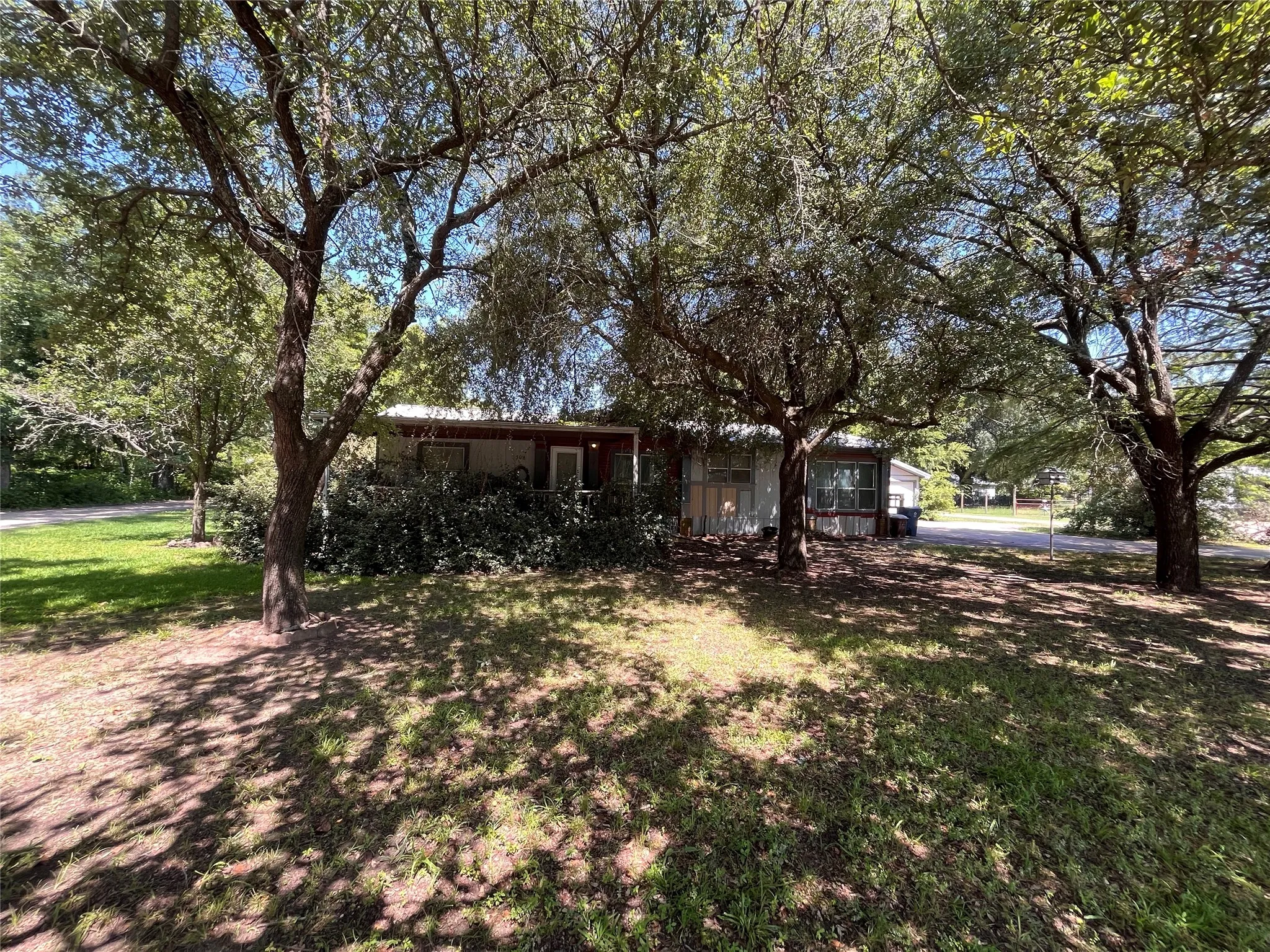Mature trees shade the front of the house