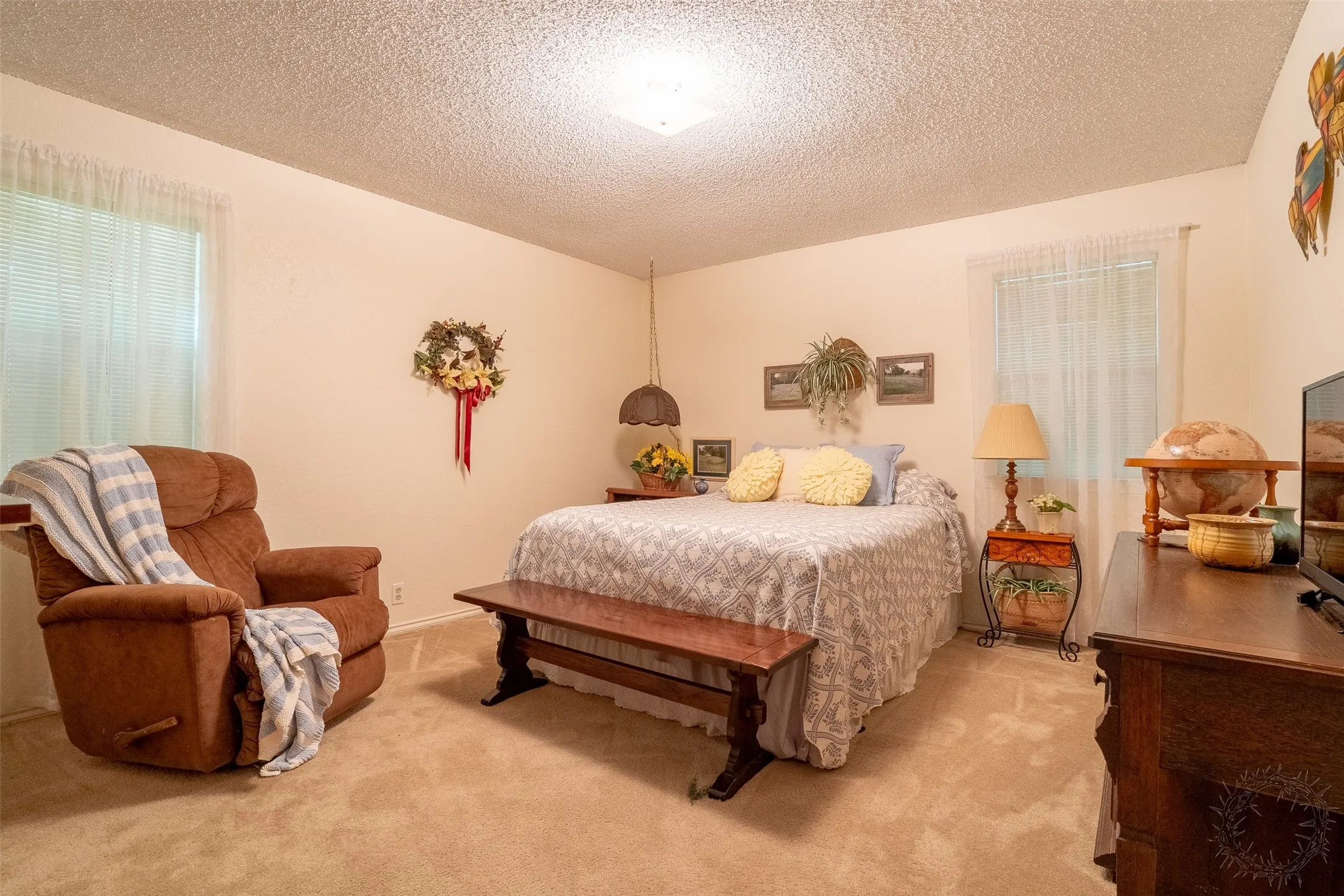 Carpeted room featuring light-toned walls and a textured ceiling