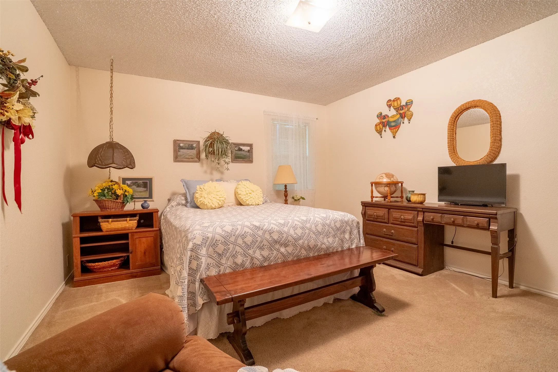 Carpeted room with a textured ceiling, a light-colored wall finish, and a window with sheer coverings