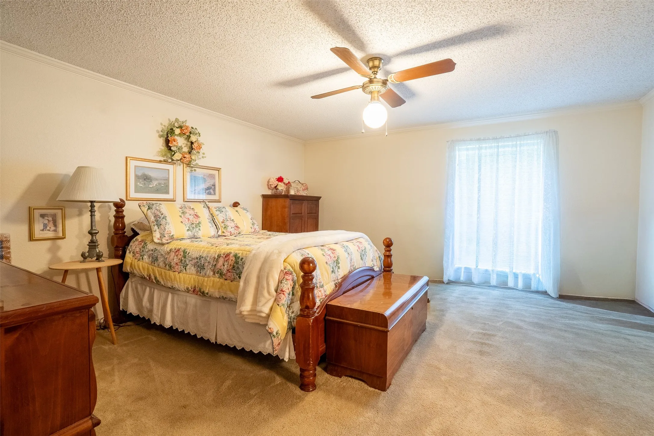 Spacious room featuring carpet flooring, light-colored walls, and a ceiling fan with integrated lighting
