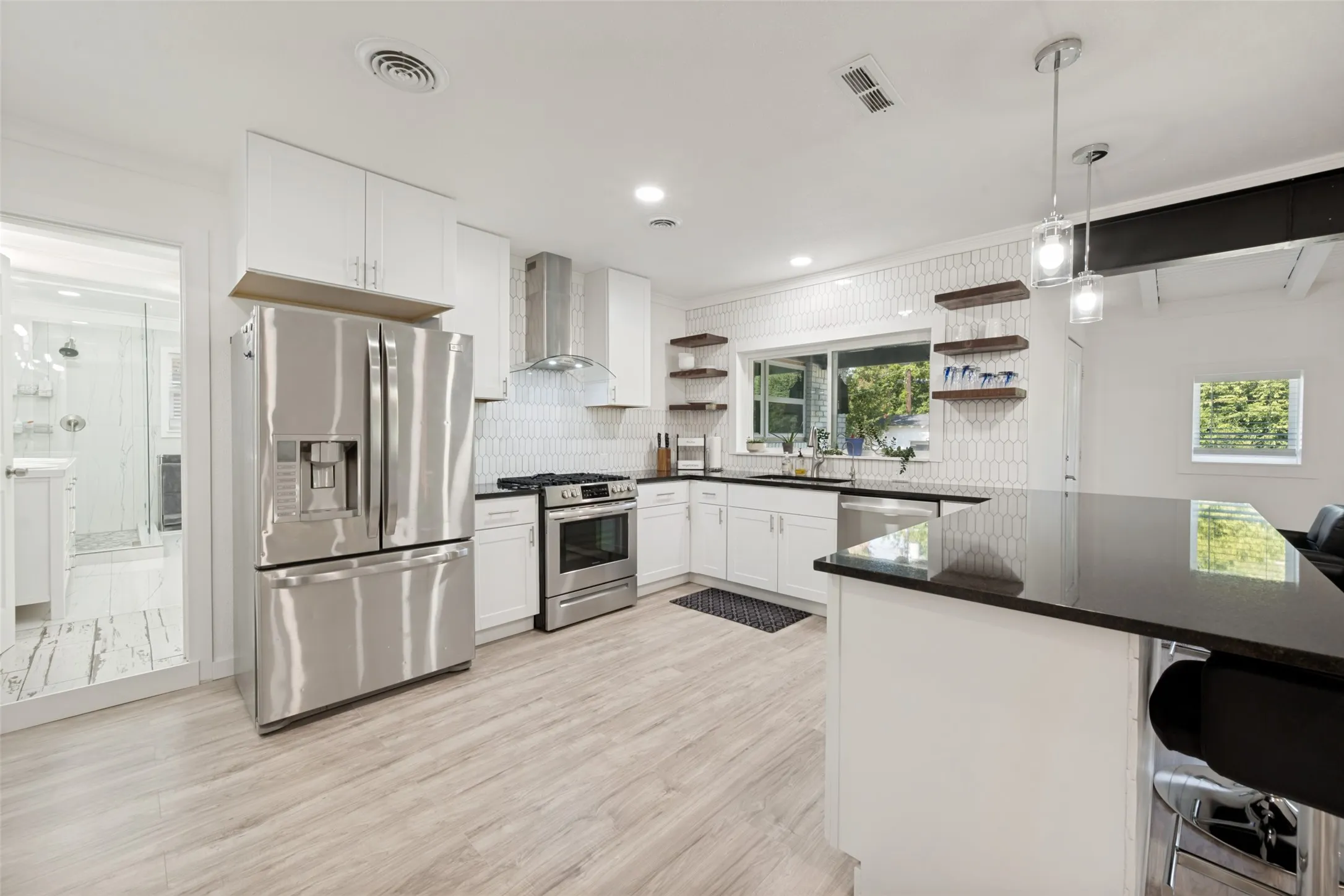 Modern kitchen featuring white cabinetry and light wood-look flooring