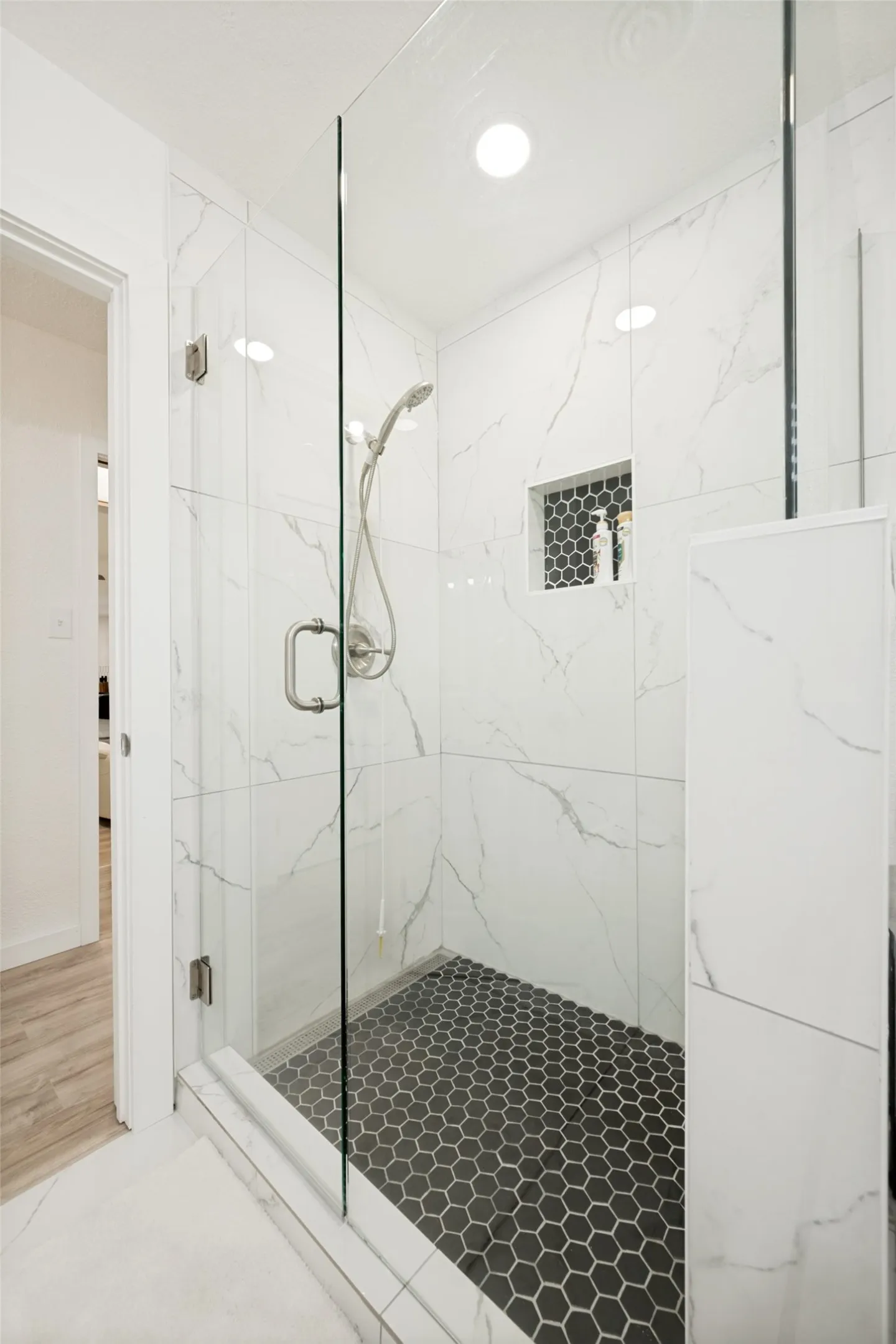 Walk-in shower with clear glass enclosure and brushed nickel hardware