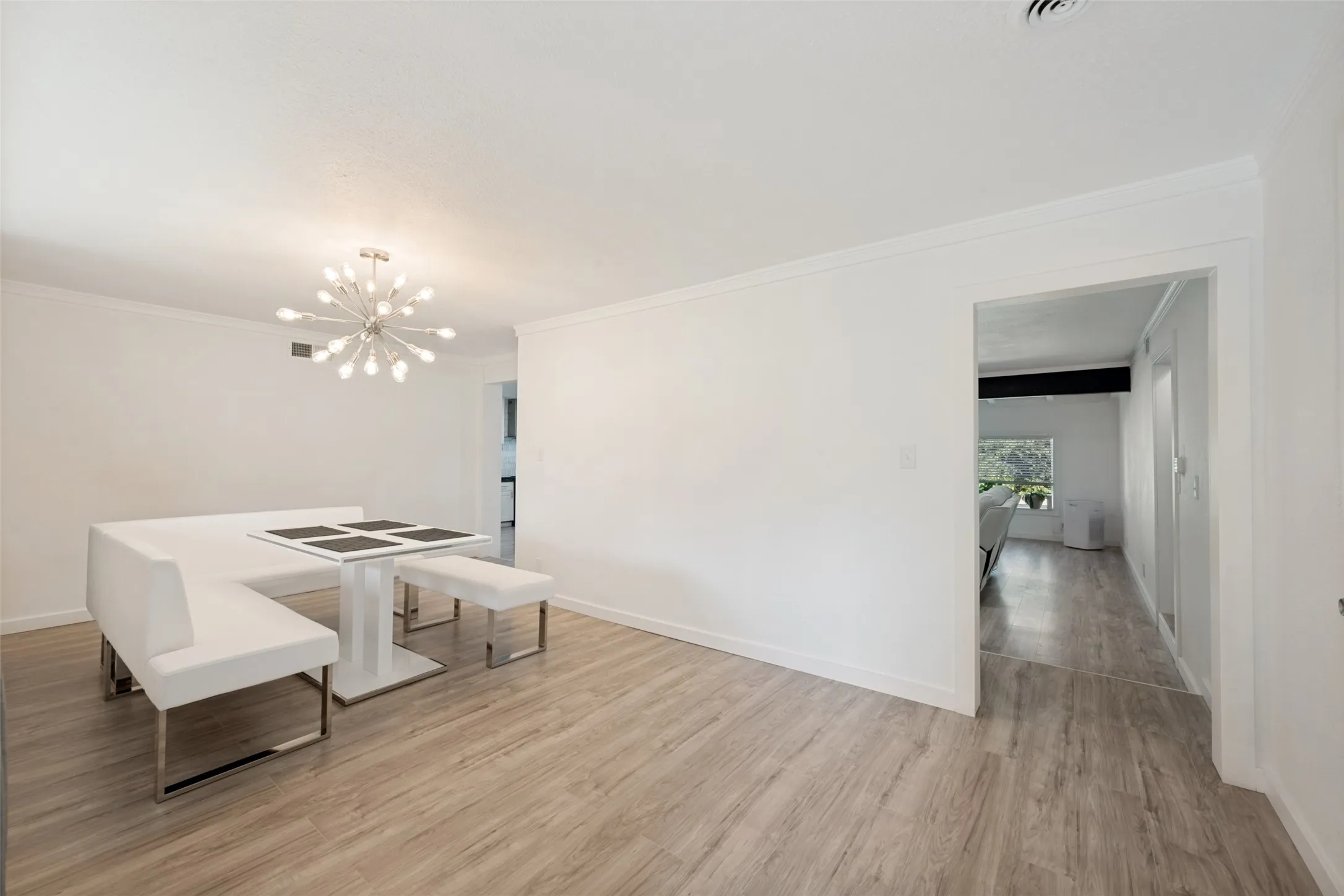 Dining area featuring wood-finish flooring and crown molding