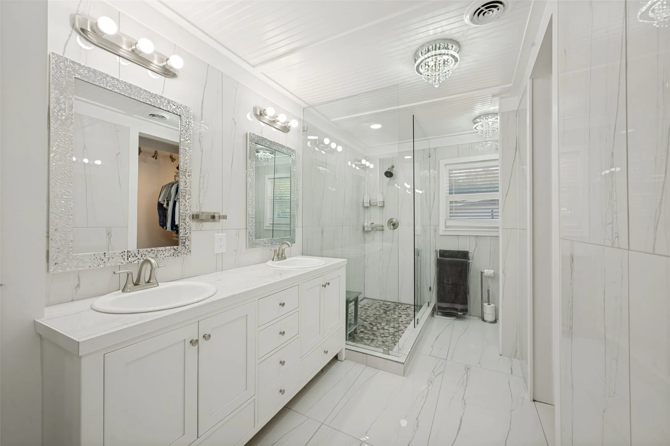 Dual vanity with white cabinetry, integrated sinks, and brushed nickel fixtures