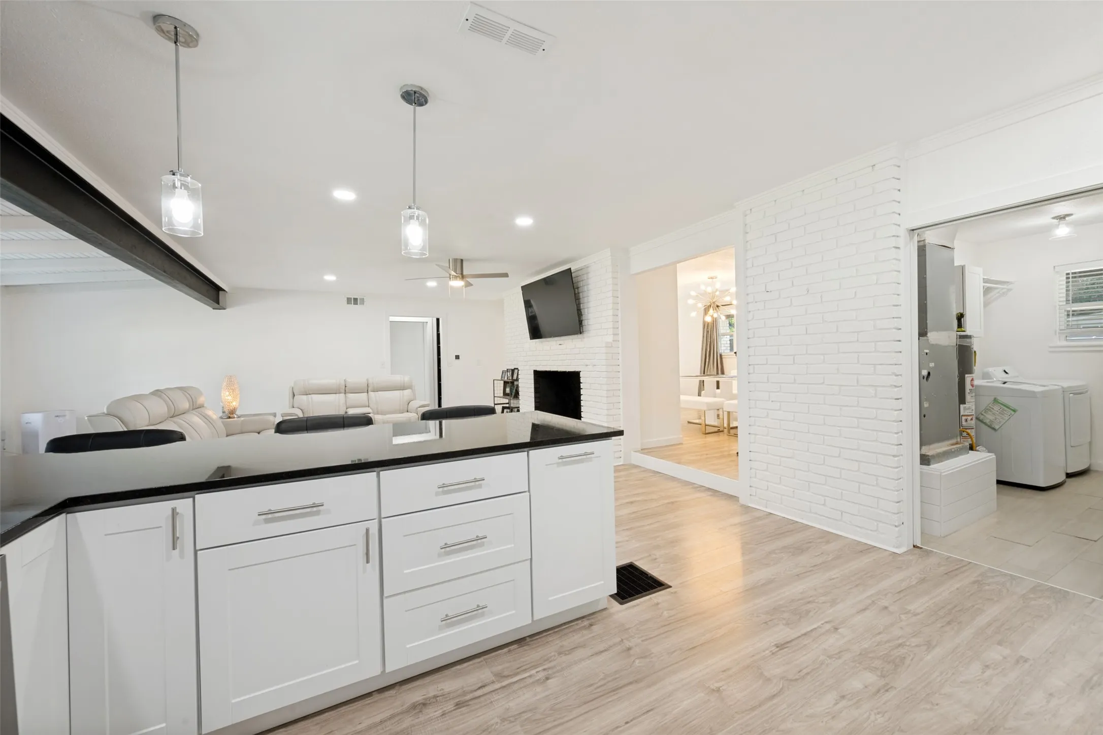 Kitchen island with white shaker-style cabinetry and a black countertop