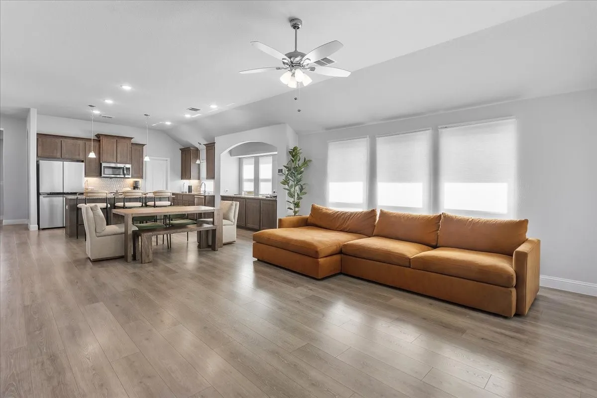 Open-concept living area featuring wood-finish flooring, recessed lighting, and a ceiling fan