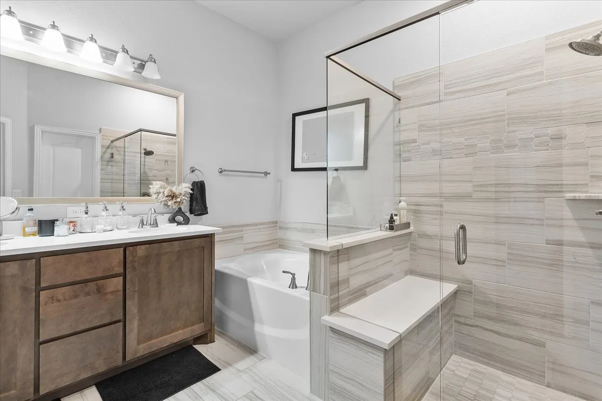 Bathroom featuring a dual vanity with a white countertop and wood-finish cabinetry