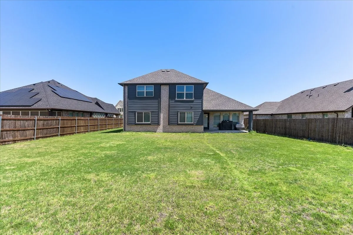 Expansive rear lawn featuring a privacy fence