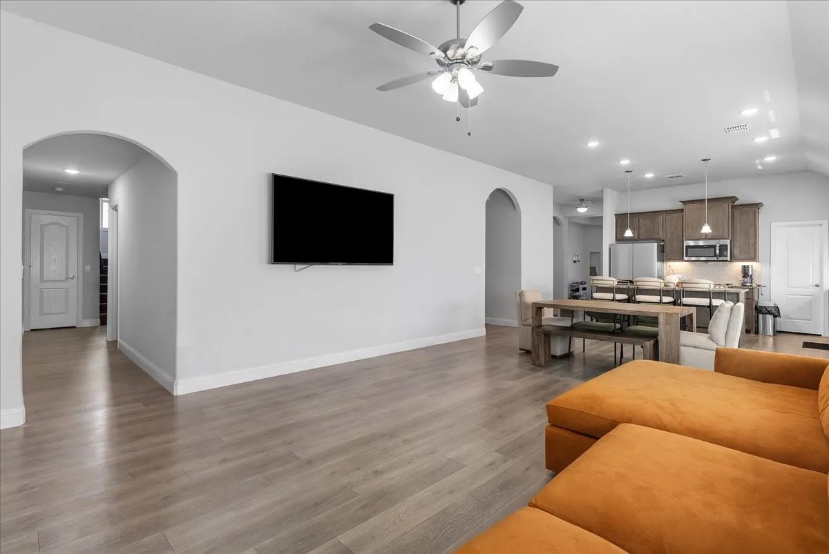 Open-concept living space featuring wood-finish flooring, a contemporary ceiling fan, and recessed lighting