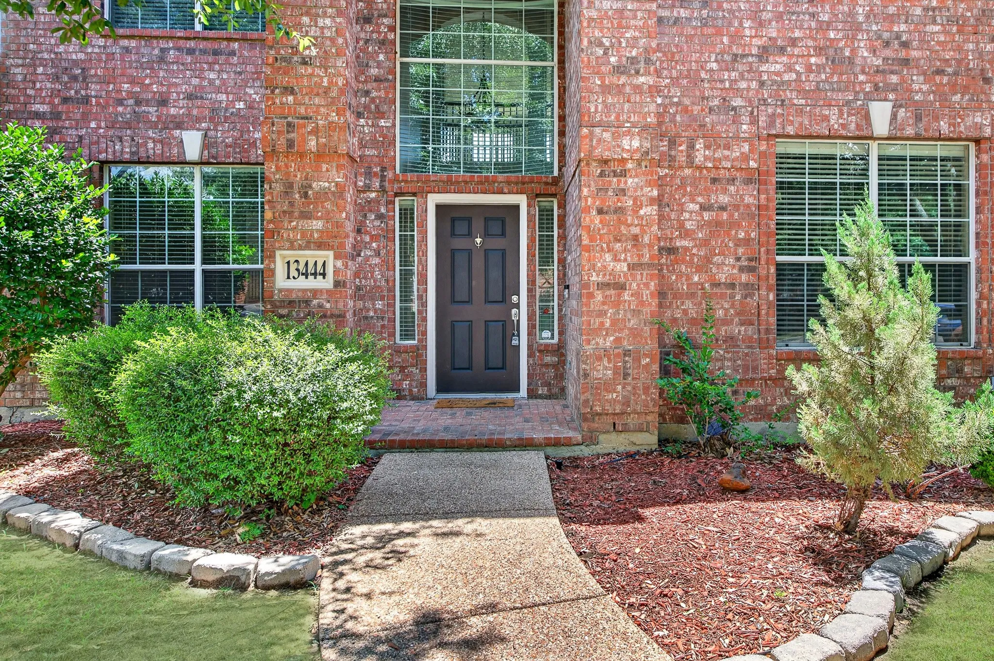 Brick exterior featuring an arched transom window above the main entry