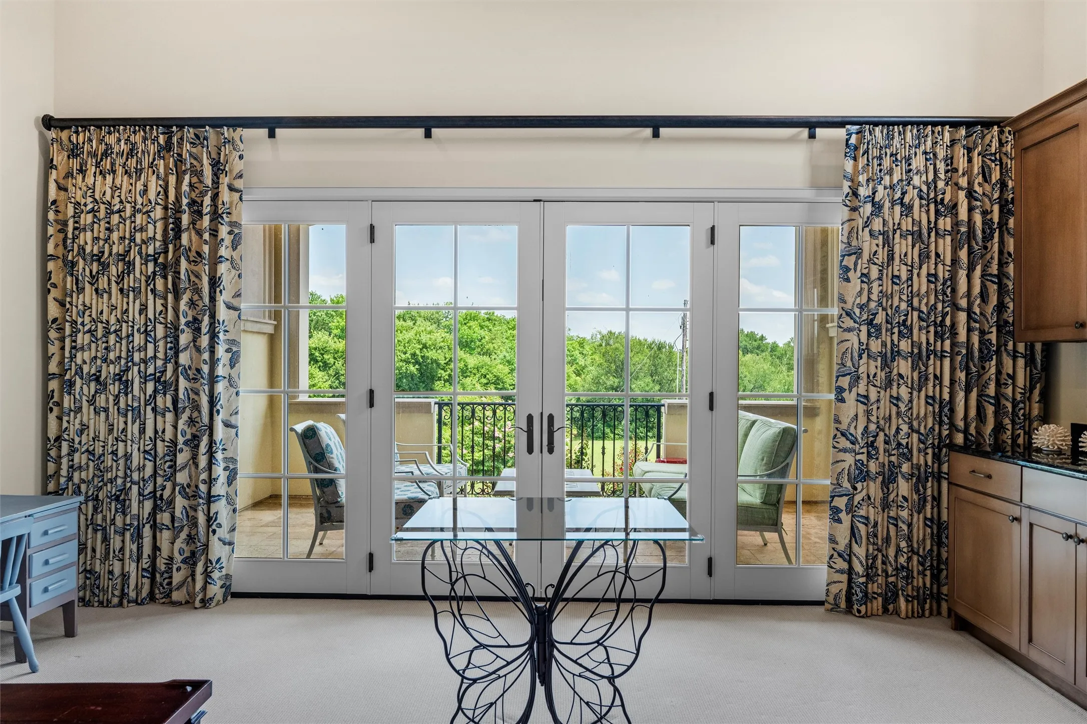 Tucked away in the guest wing, the second floor family room provides a wealth of potential uses, with a wall of windows leading to the covered patio and views of the expansive, lush grounds.