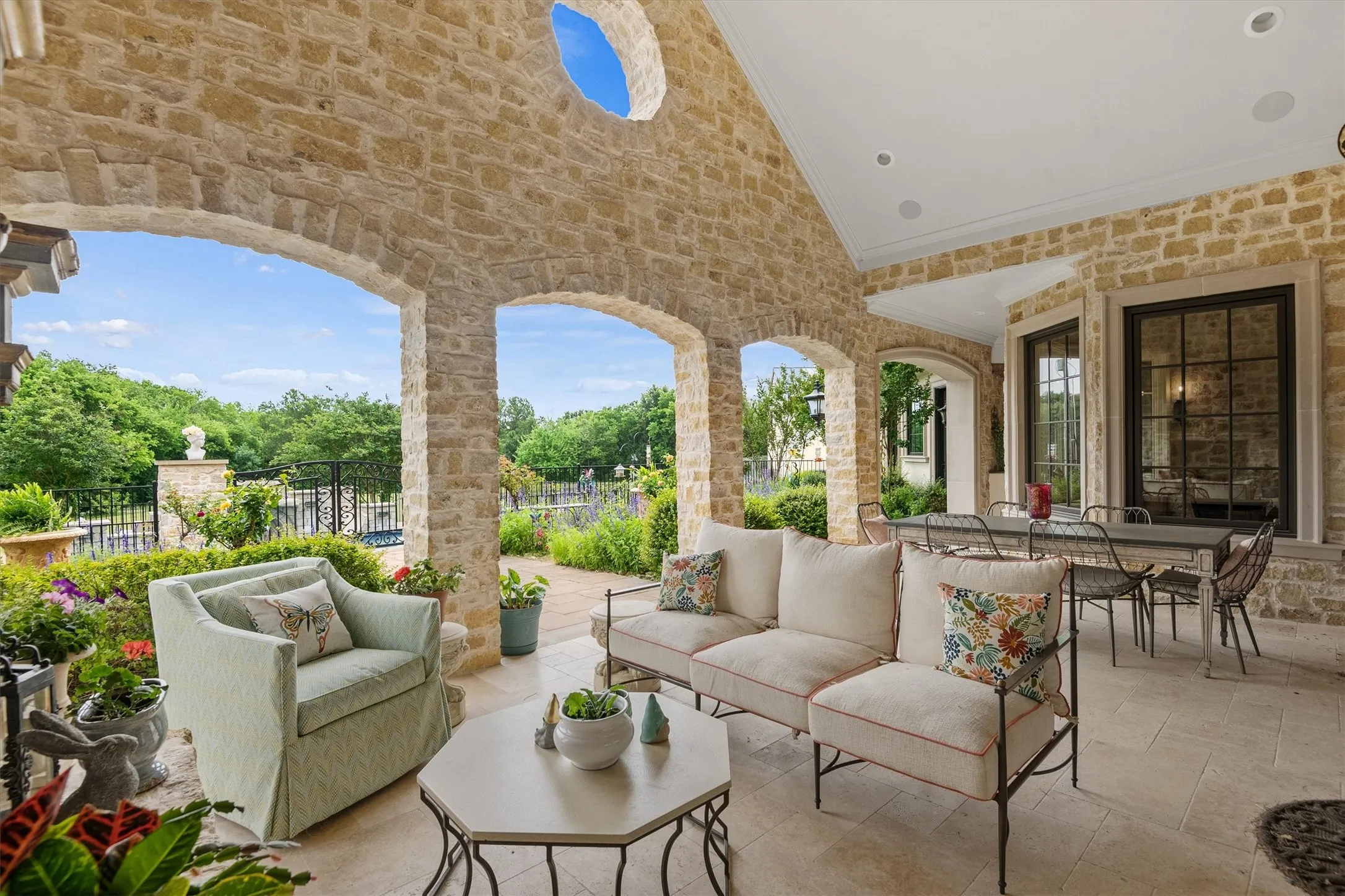 The rough faced limestone walls of the large covered patio add a rich, cozy feel to the outdoor living space.