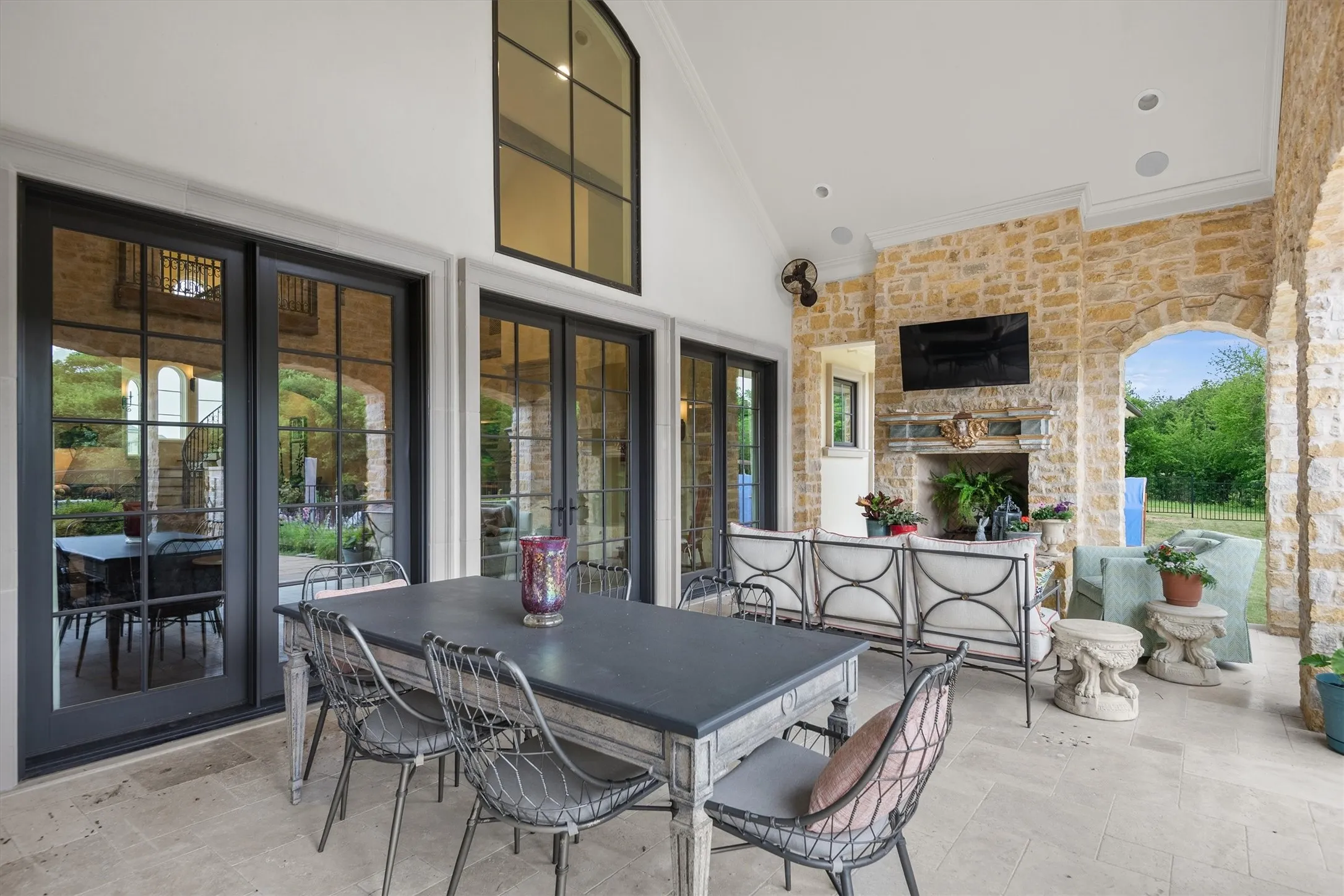 The patio not only provides rooms for several vignettes, but also for a dining table.  Also notice the outdoor fireplace, fans, and outdoor television!  The patio is truly an extension of your living area!