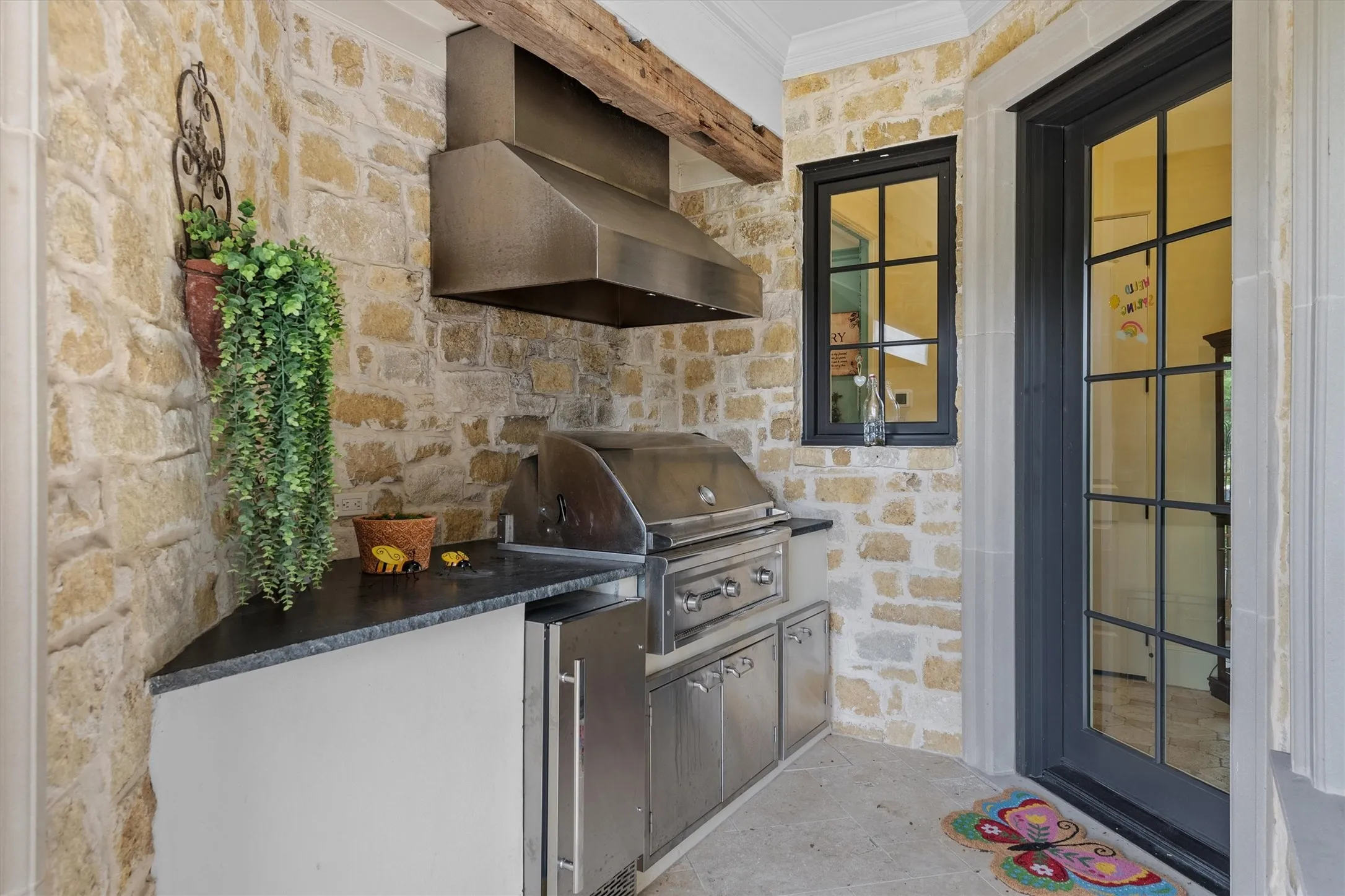 The gas grill is tucked away in a wing of the patio with its own vent a hood to keep the smoke from entering the patio.