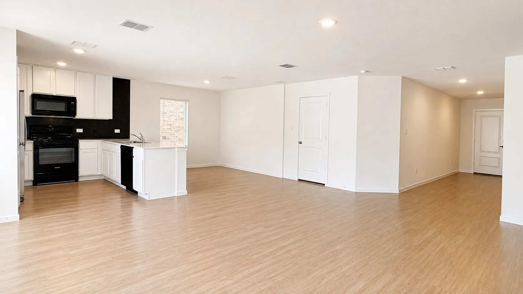 Open-concept layout featuring wood-finish flooring, recessed lighting, and a kitchen island