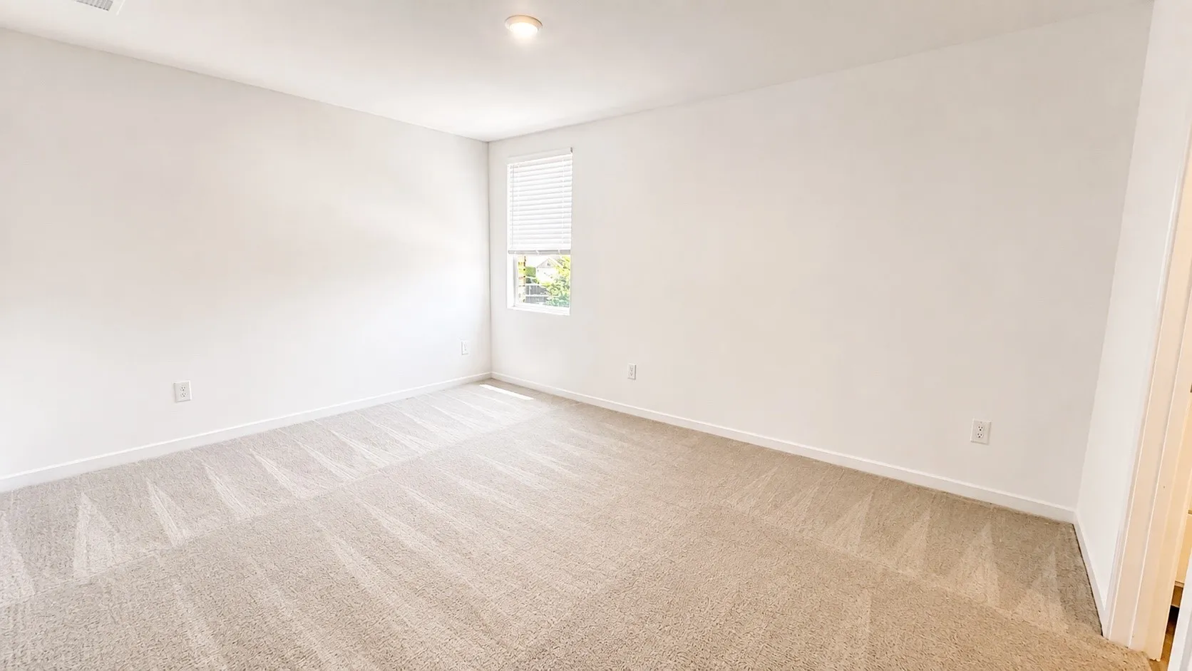 Recessed ceiling lighting, a window with blinds, light-toned carpeting, and neutral wall tones