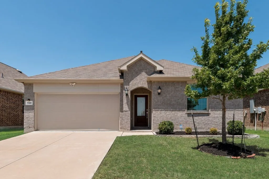 Traditional style brick exterior with stone accents, a two-car garage, and a covered entry