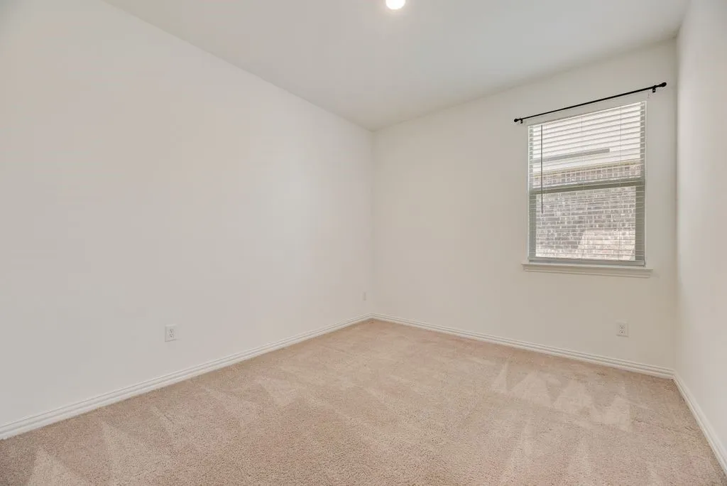 Carpeted room with a single window featuring horizontal blinds