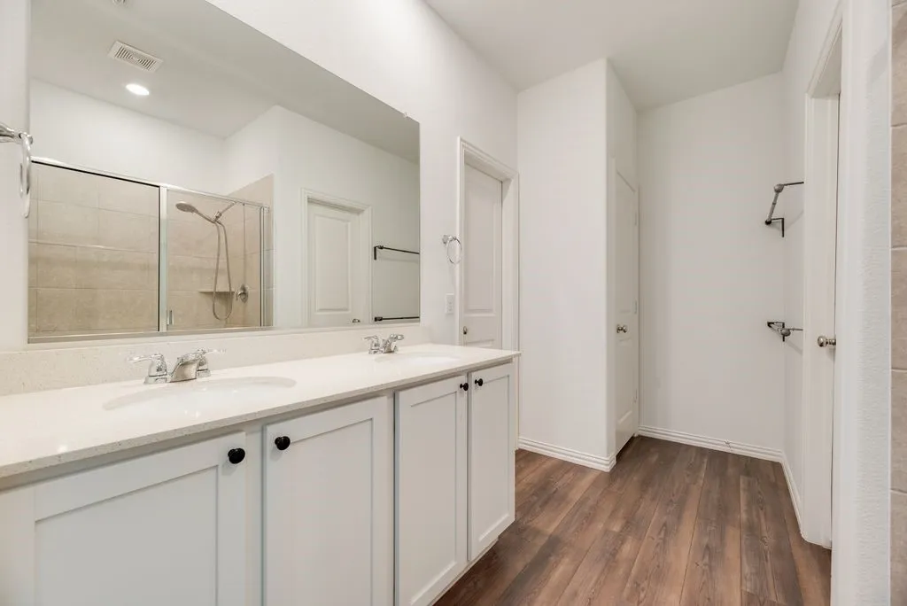 Dual vanity with white shaker-style cabinetry, white countertops, and chrome faucets