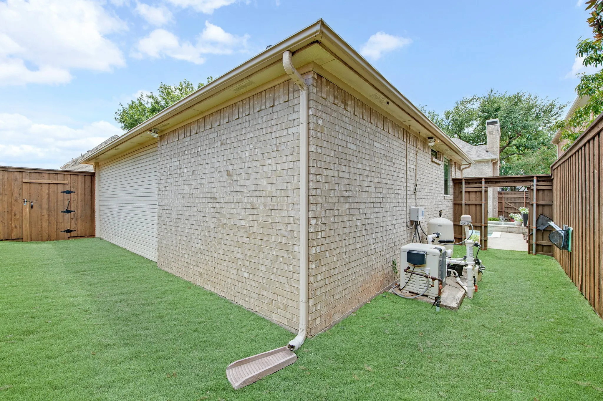 Side yard featuring artificial grass and dog run.